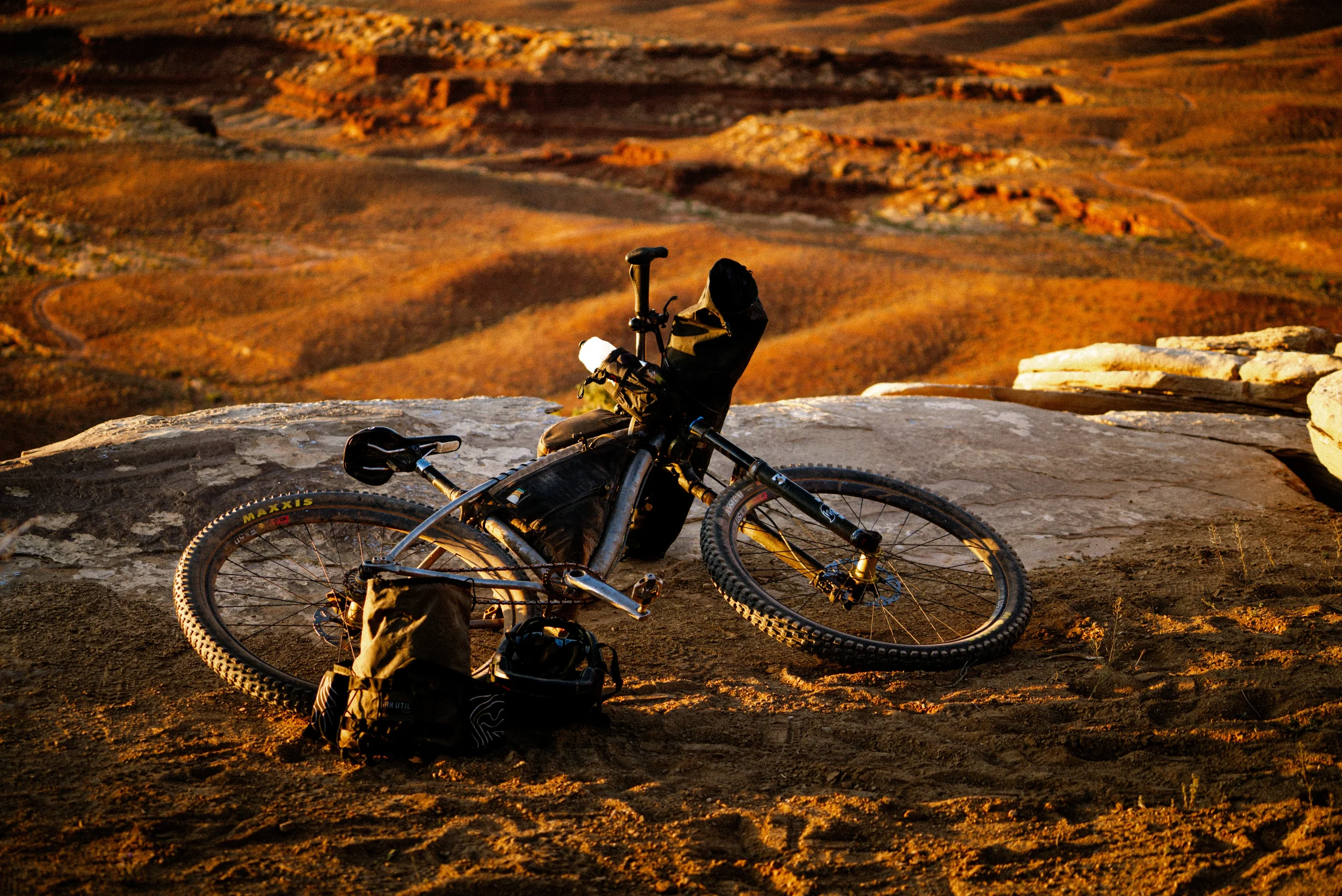 bikepacking bike laying on desert sandstone
