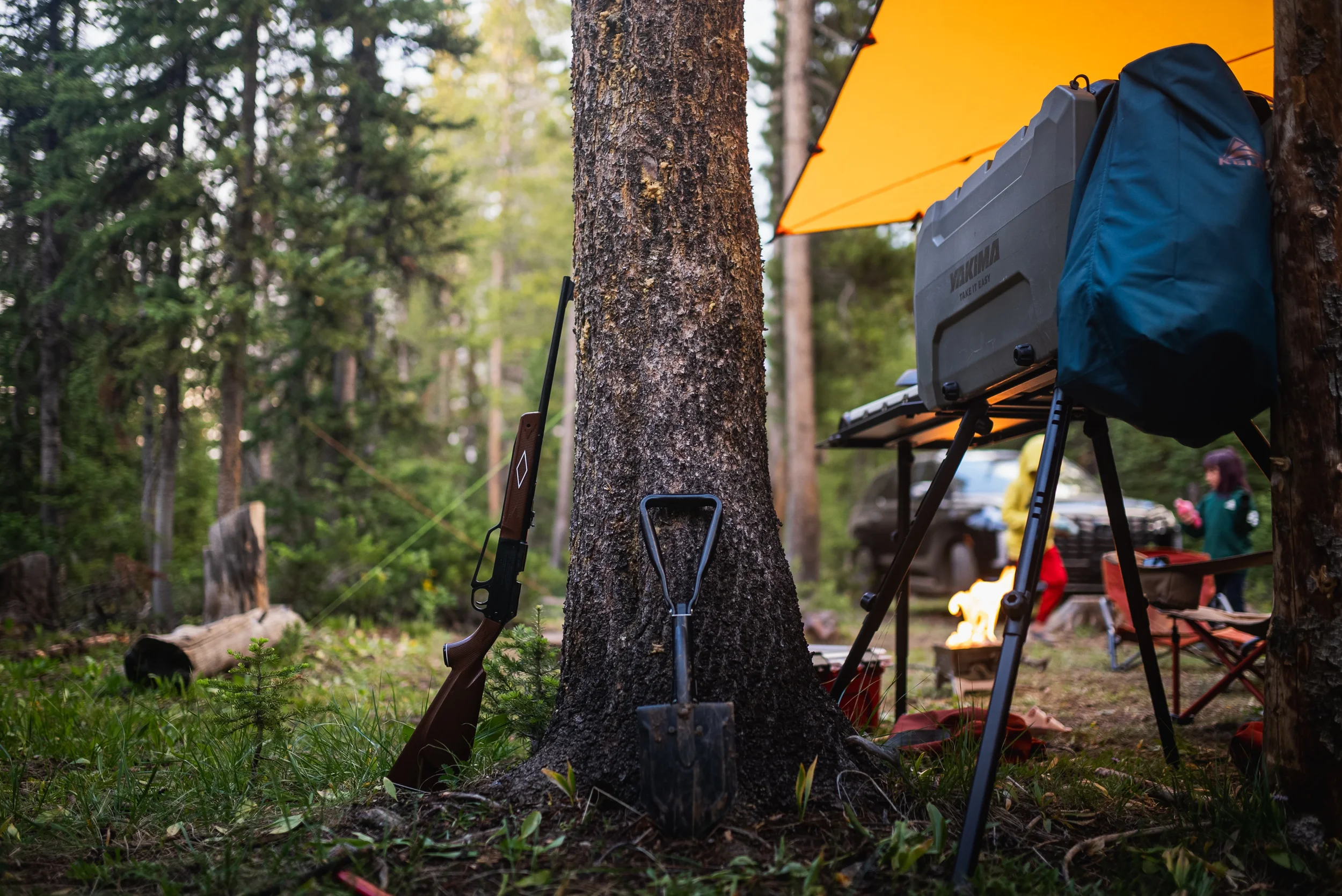 campsite with bb gun leaning against a tree