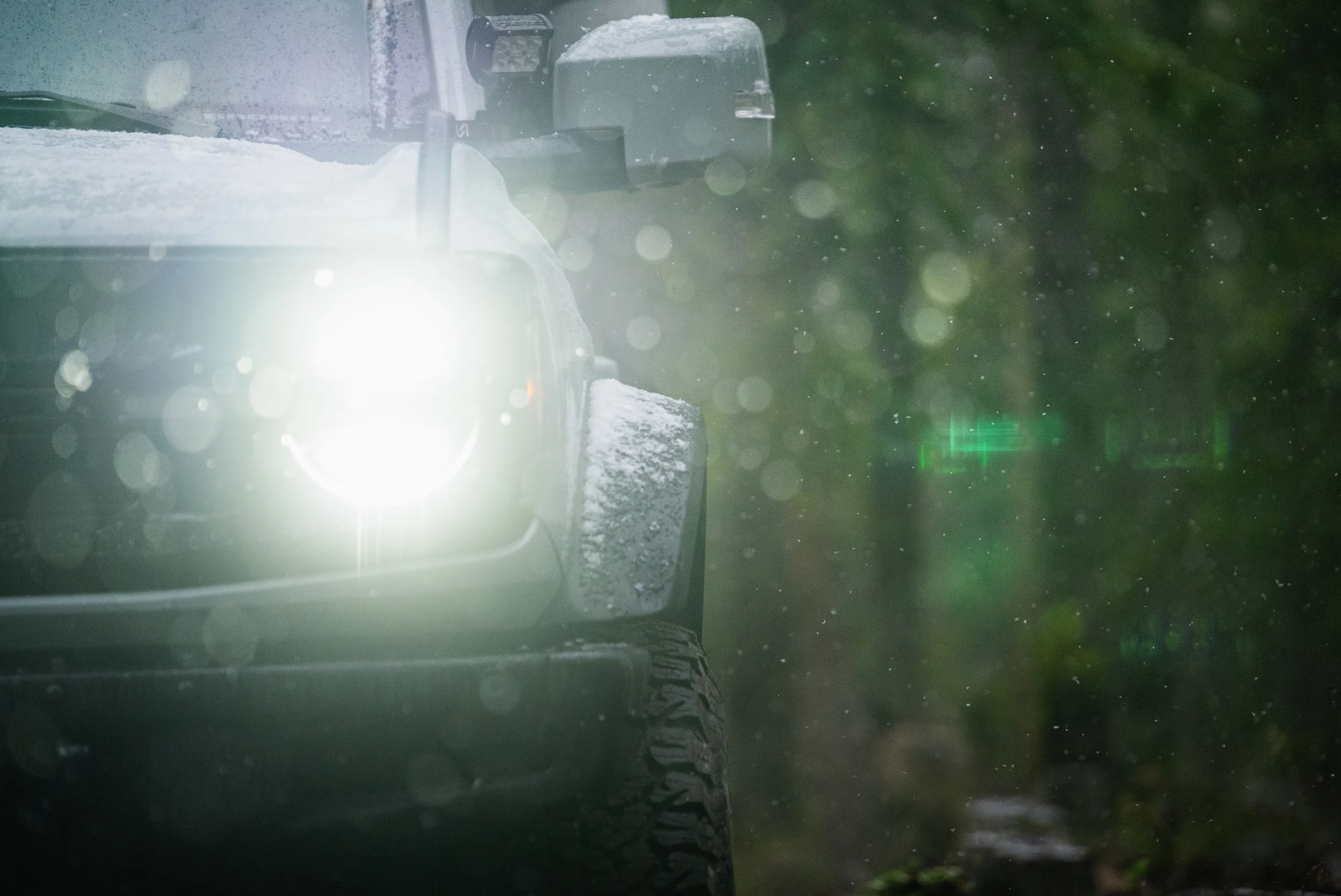 snowflakes highlighted by bronco headlights