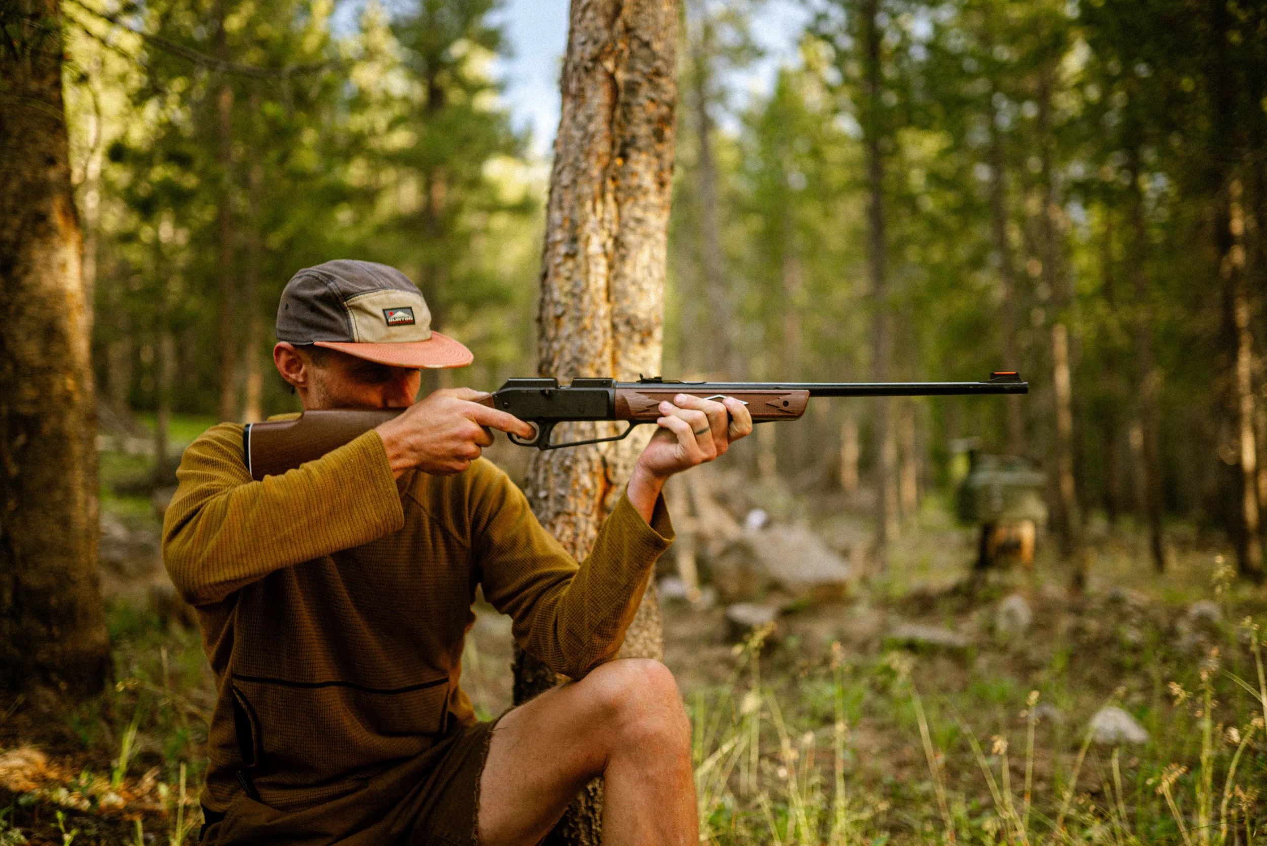man aiming a bb gun while camping