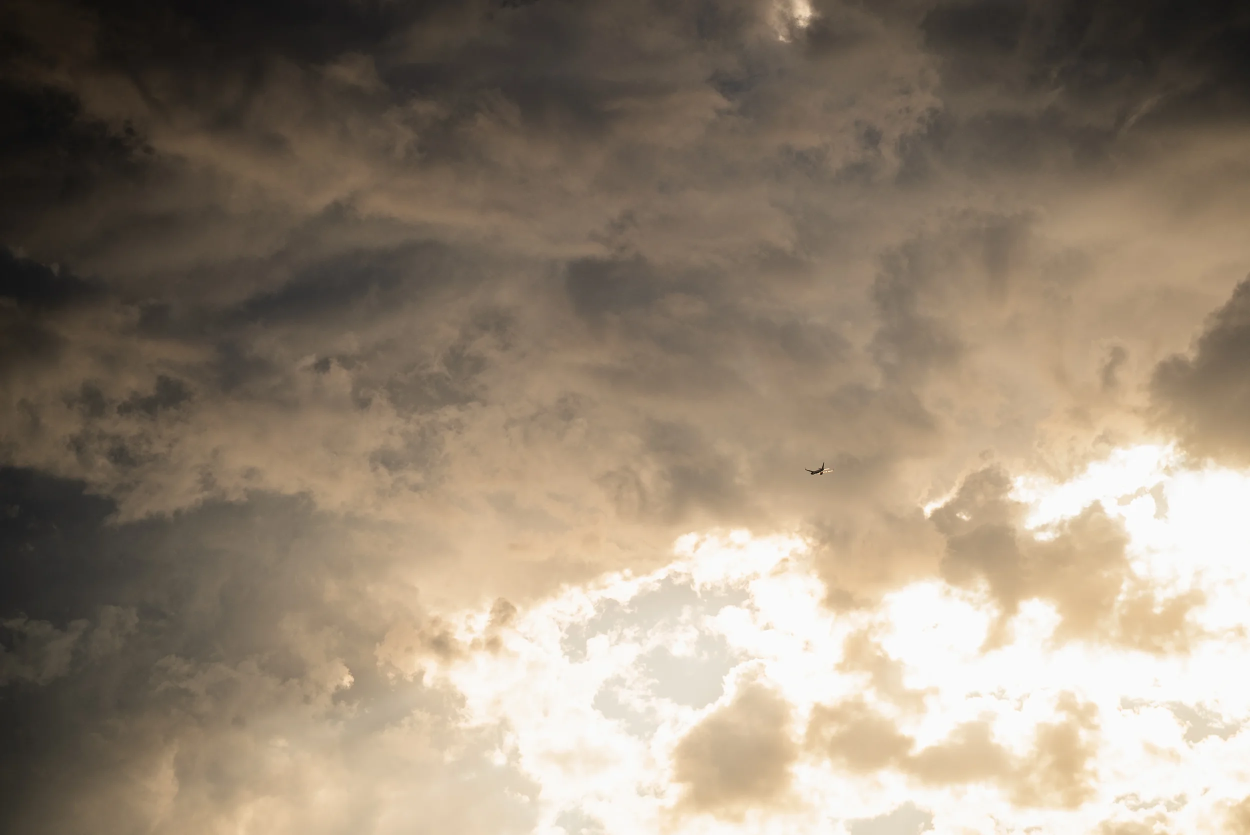airplane silhouette in front of storm clouds