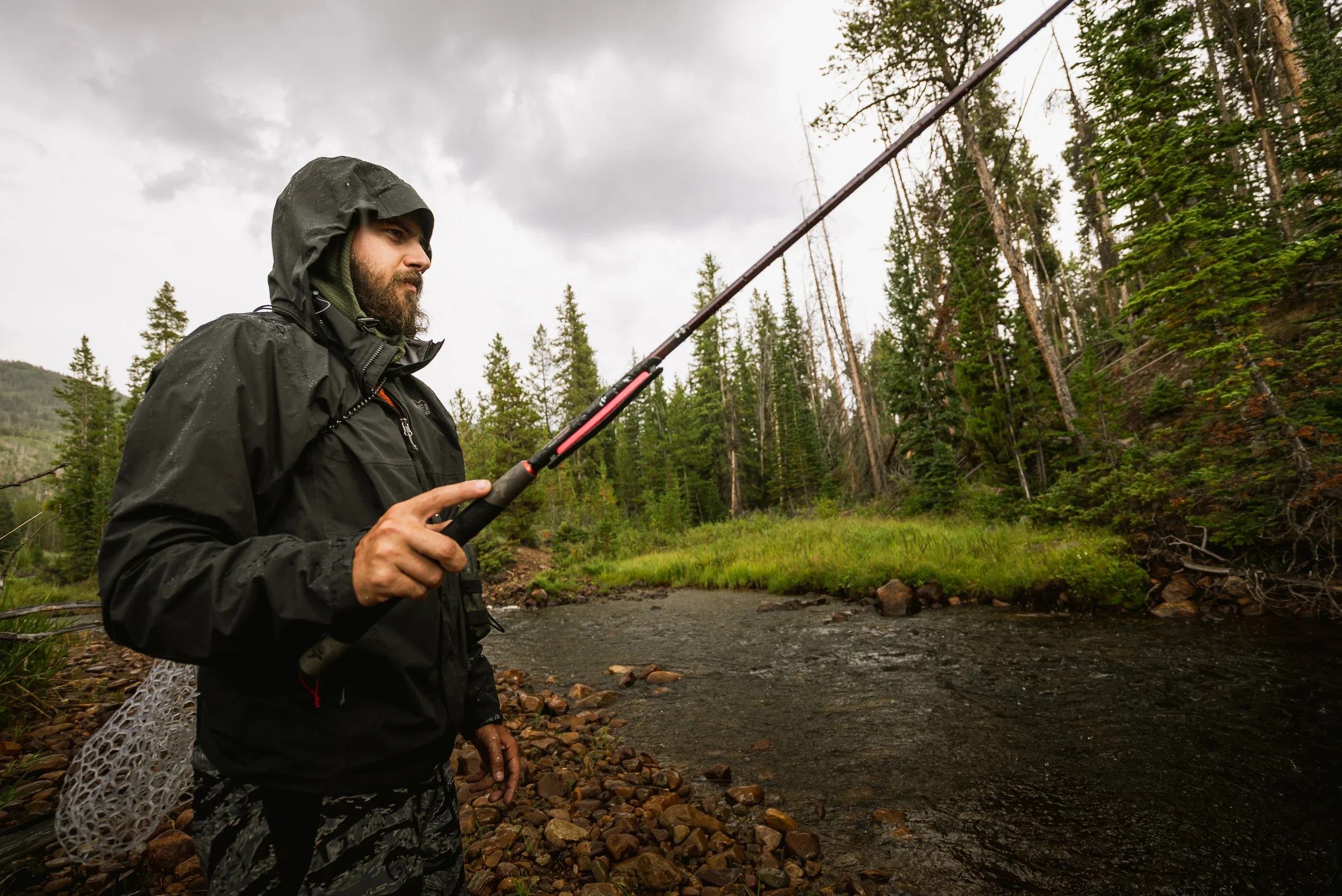 man fly fishing in the rain with a tenkara rod