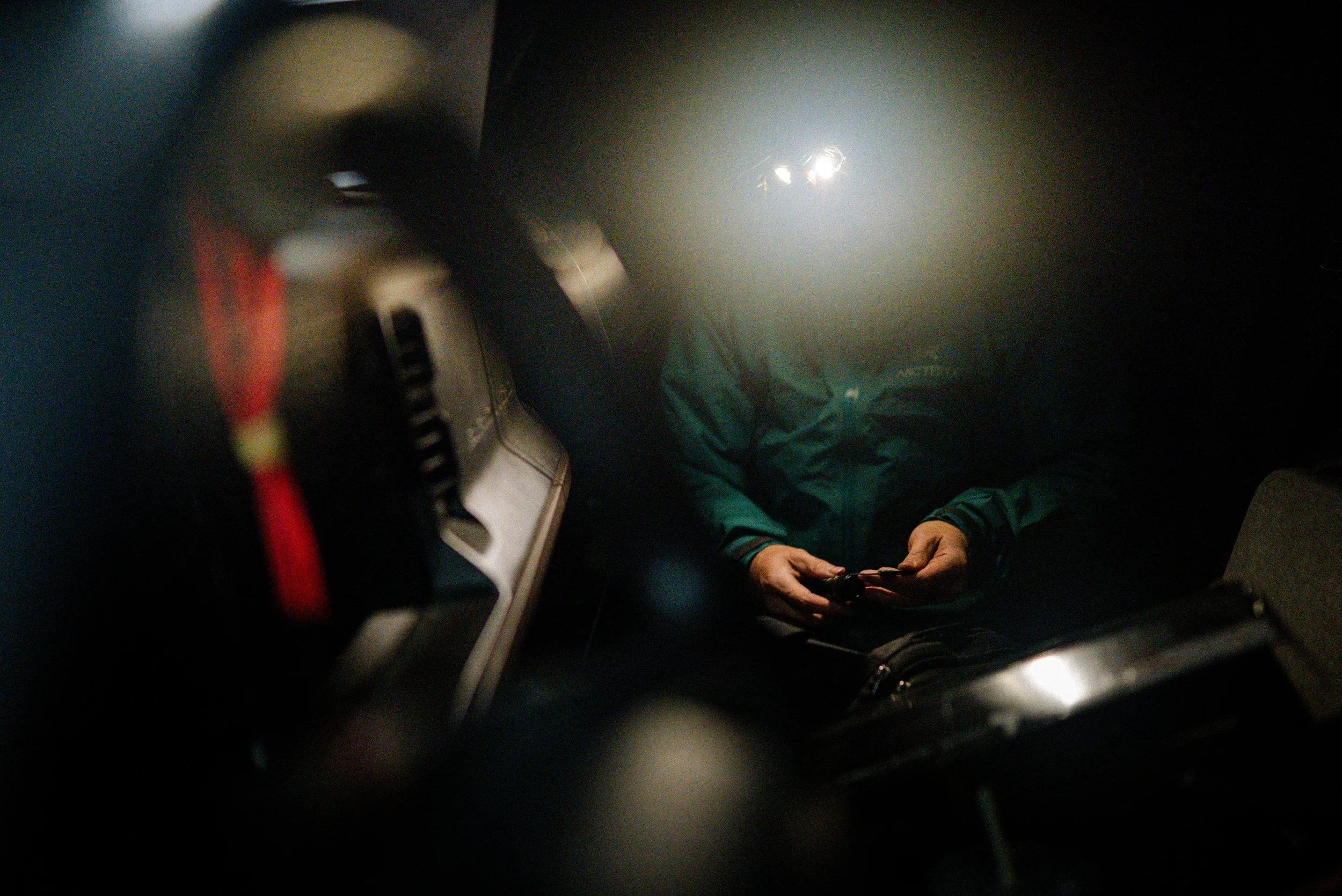 man grabbing gear in a truck at night
