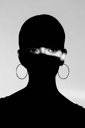 Silhouette of a woman with a head covering, large hoop earrings, and a face mask, in black and white.