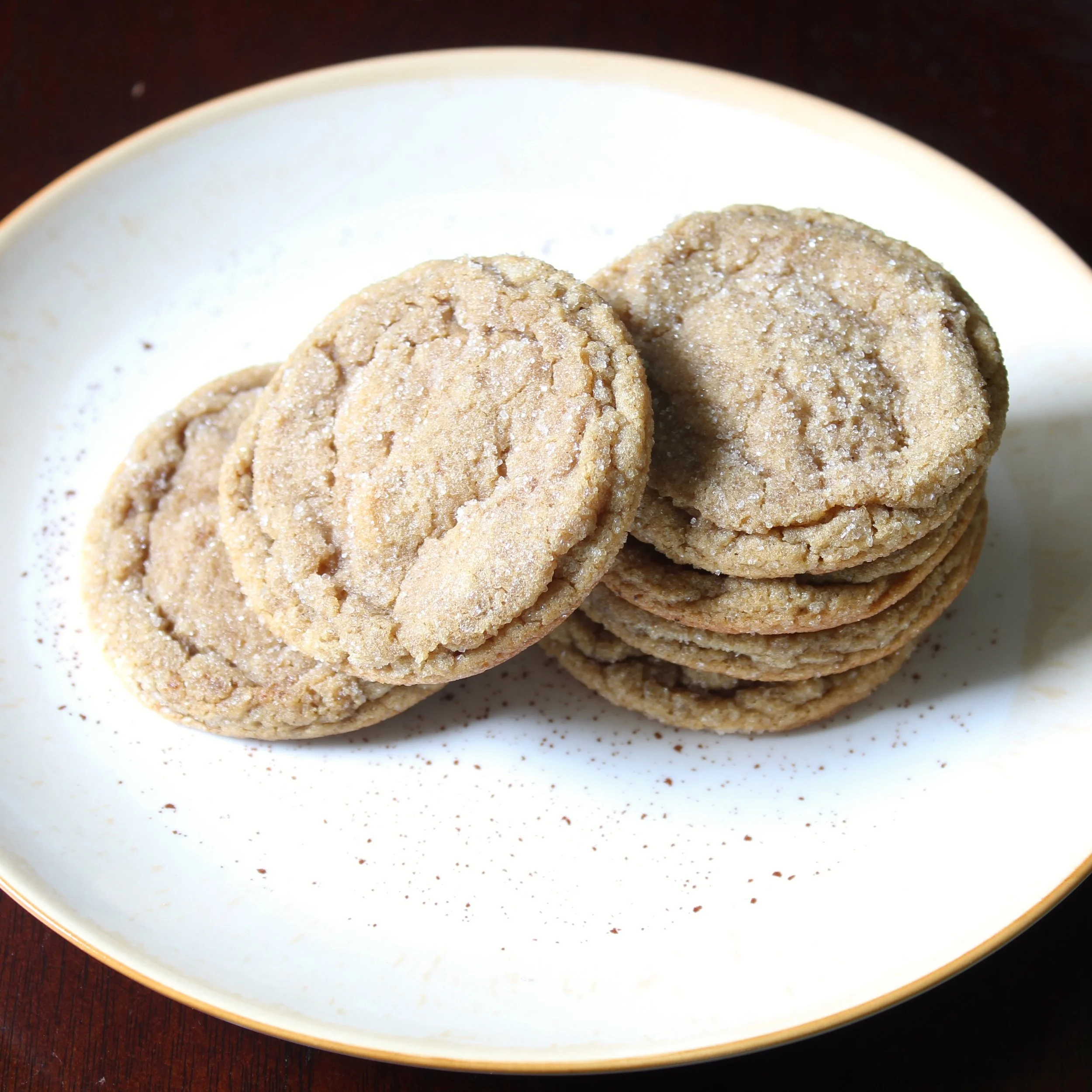 Stack of golden brown butter espresso cookies on an off-white plate.