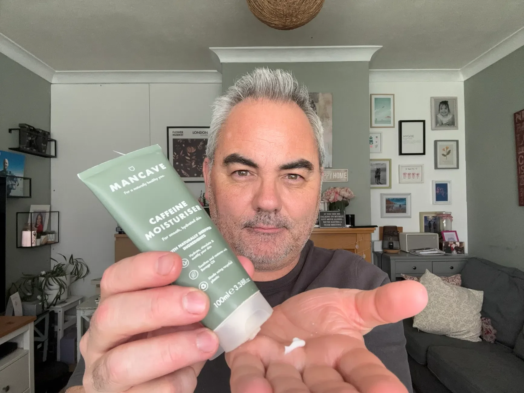 Jerome dispensing a dollop of ManCave Caffeine Moisturiser onto his palm to demonstrate its white, lightweight texture for the review.