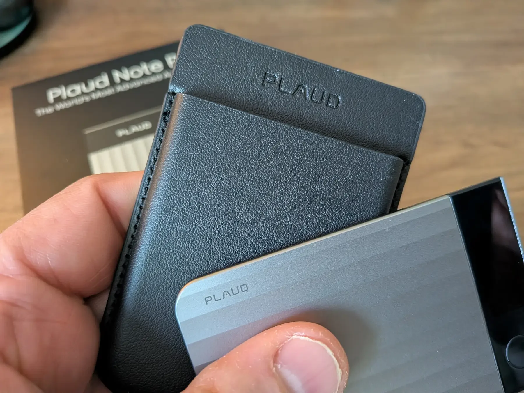 Close-up of PLAUD Note Pro next to its black protective sleeve