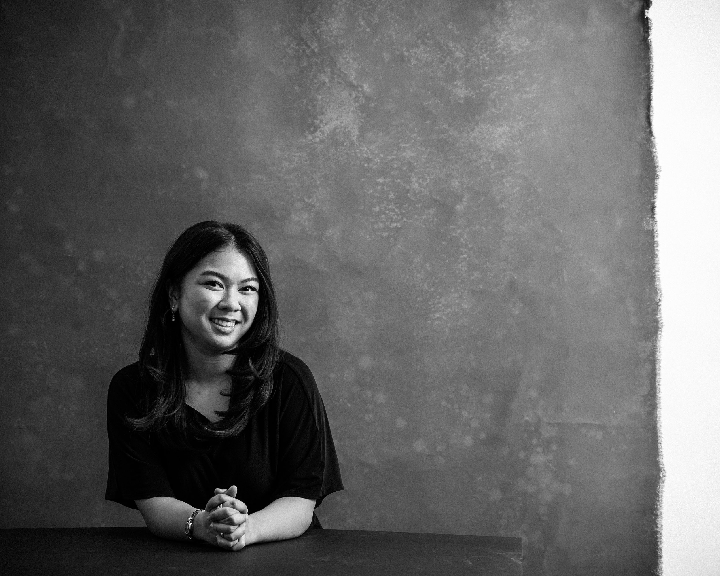 woman sitting with her hands clasped looking directly into the camera
