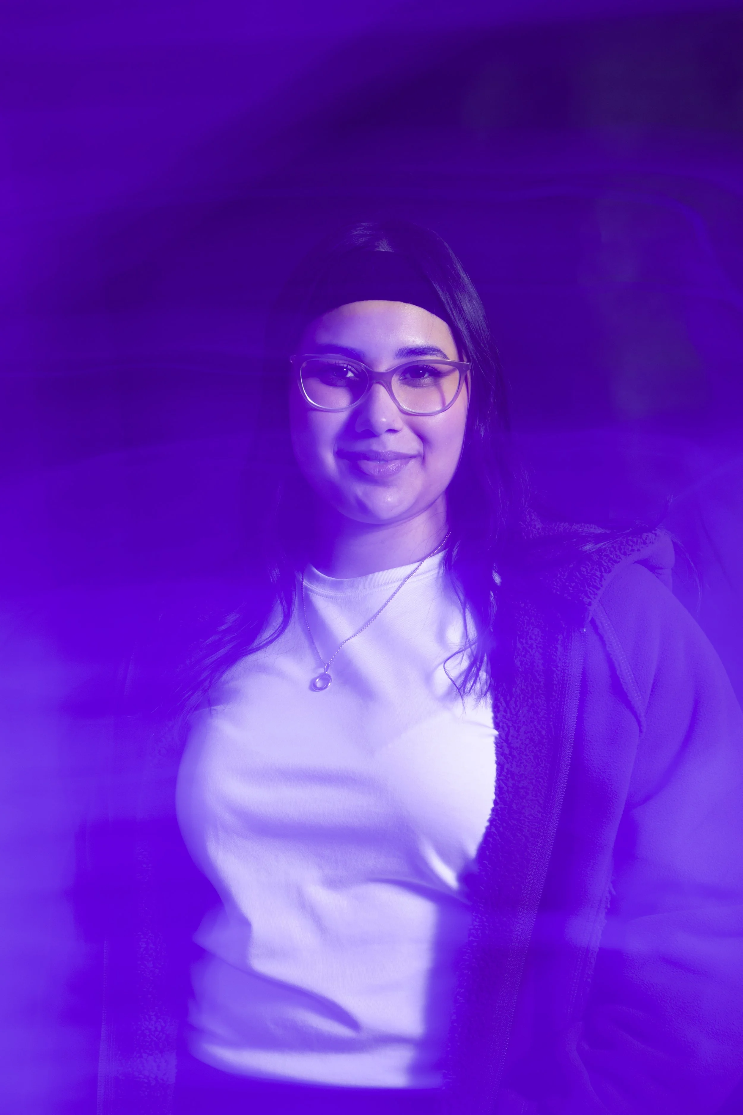 woman standing next to black wall will hazy purple overlay