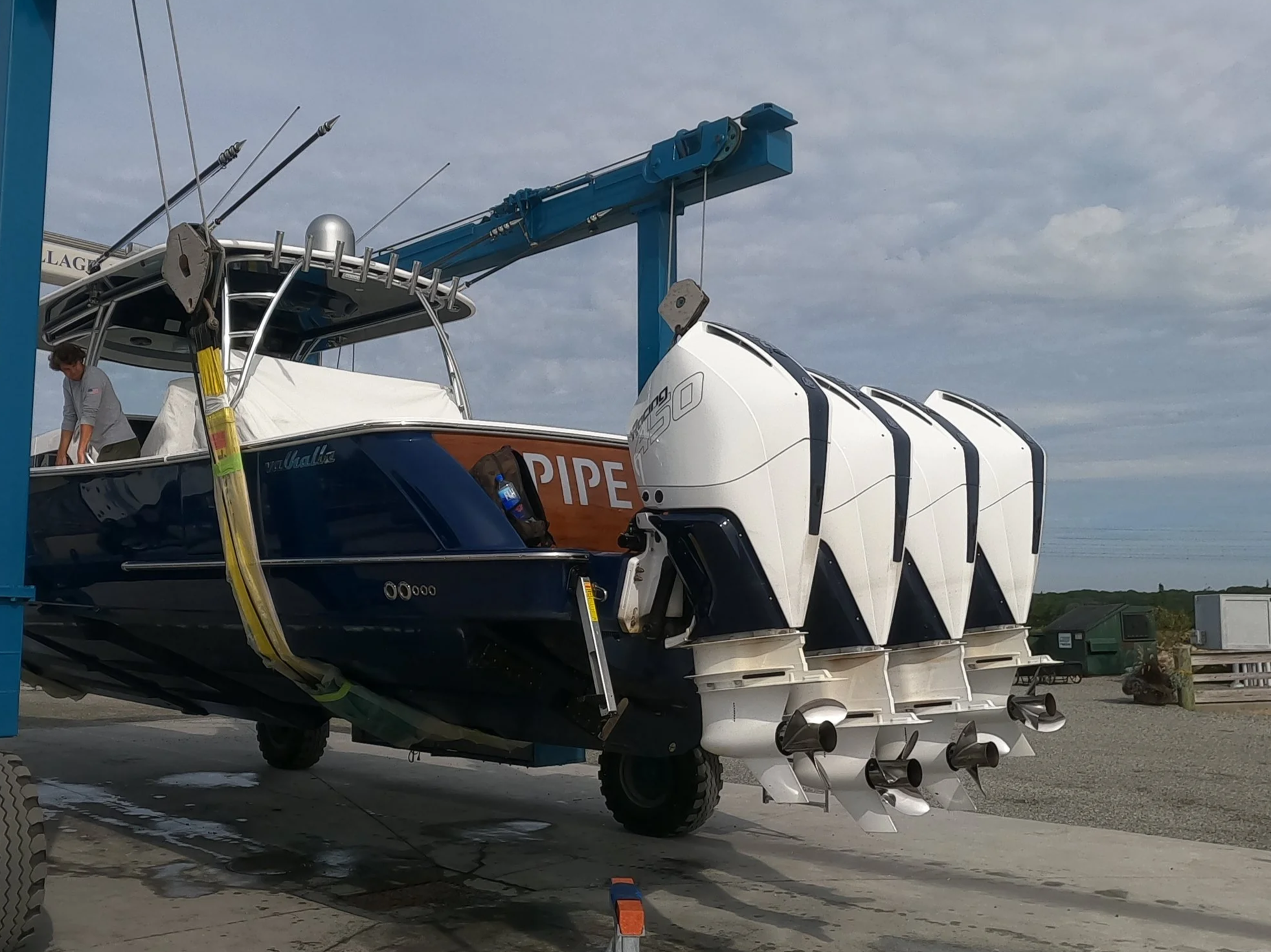 Powerboat with multiple outboard motors on a trailer at a boat storage or service yard.