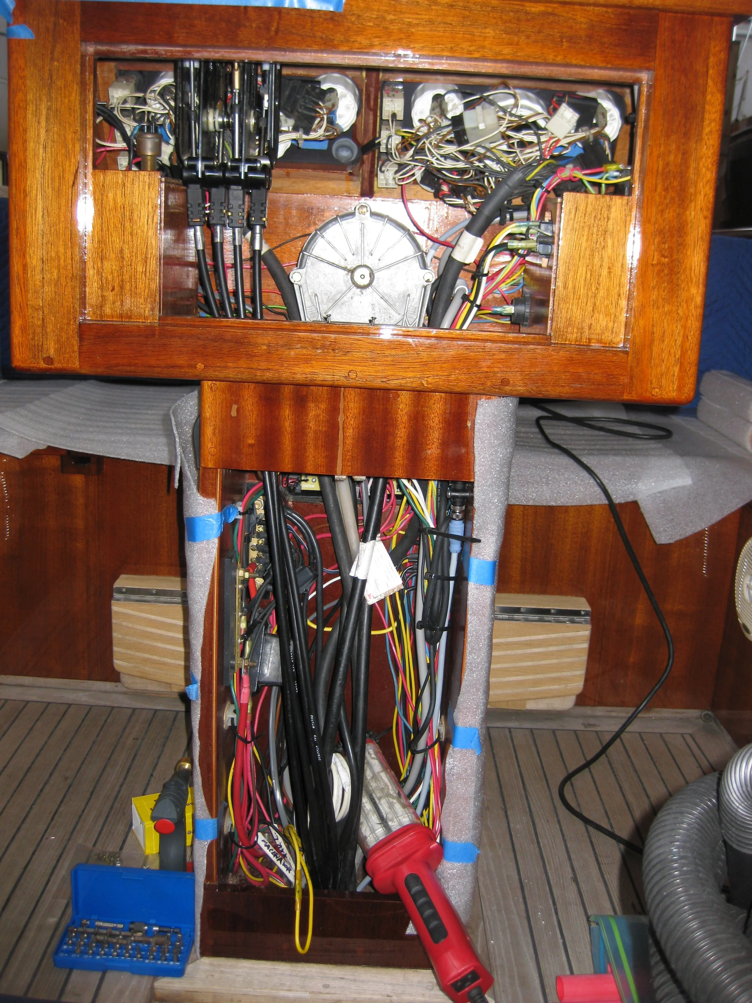 Electrical work inside a wooden structure, with wires, tools, and electrical components visible.