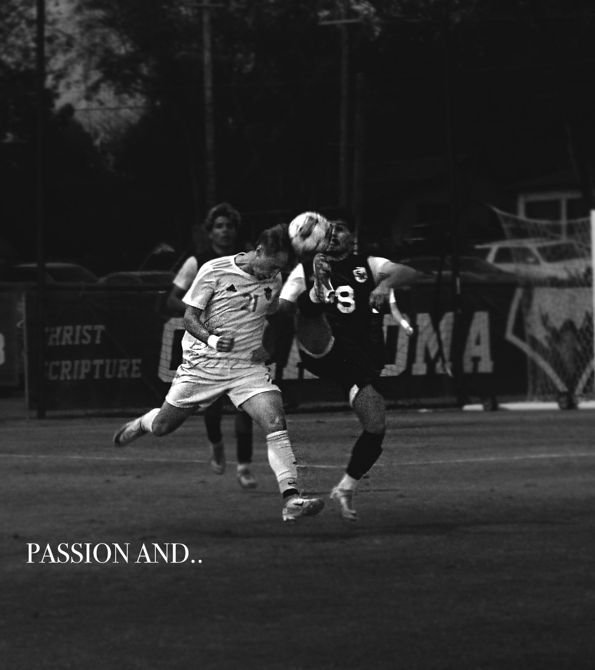 Black and white photo of two female soccer players fighting for control of the ball during a match, with one player in a light-colored uniform and the other in a dark uniform. A sign in the background reads "CHRIST SCRIPTURE," and the word "OMA" is p