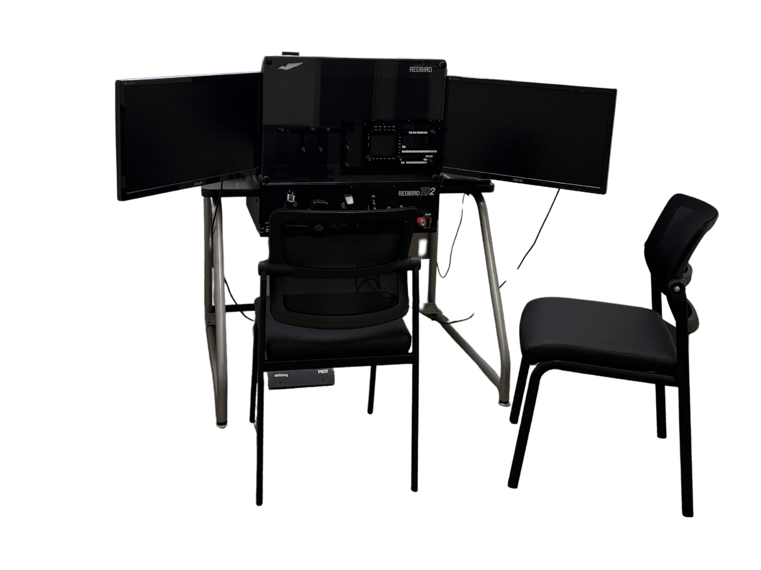 A BATD flight simulator with multiple monitors, keyboard, and chair, part of a multi-screen computer workstation setup.