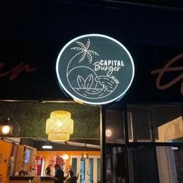 Neon sign for Capital Burgers with a palm tree and burger graphic