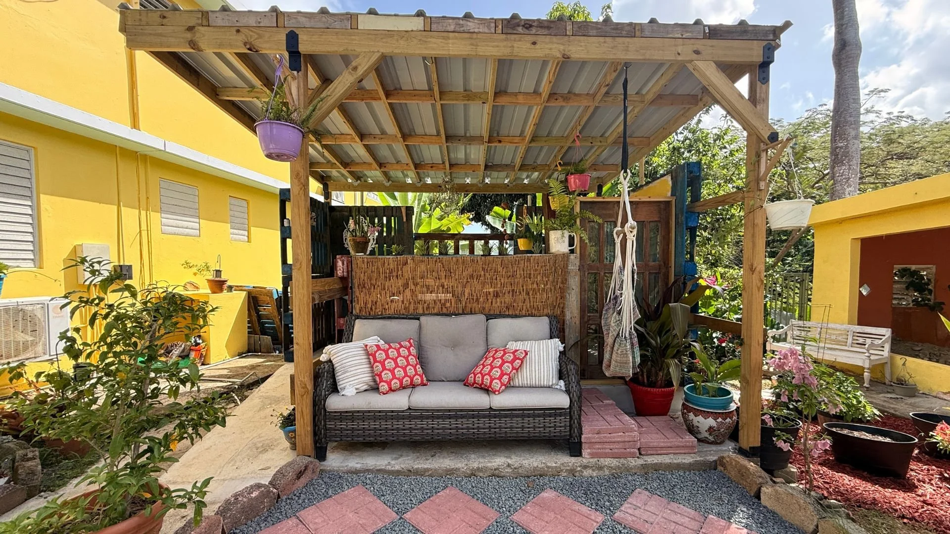 A shaded perch above the pool and garden, where slow afternoons drift between wildflowers, palms, and banana trees.
