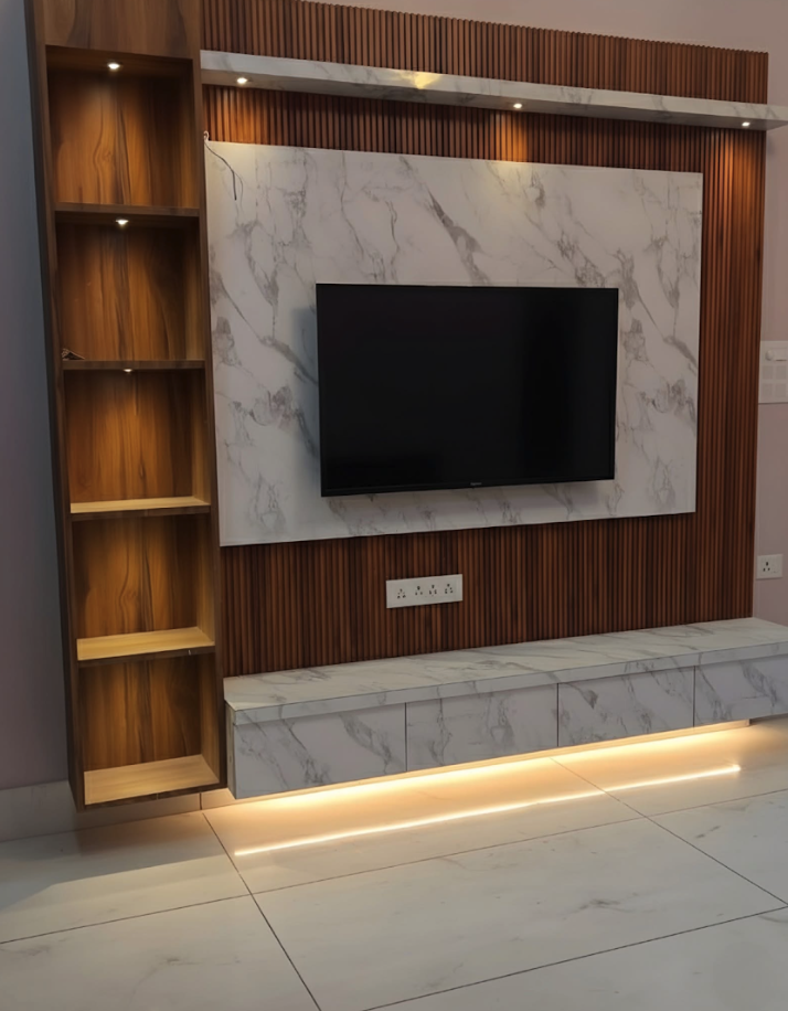 Modern living room wall with mounted flat-screen TV, marble accents, wooden paneling, and built-in shelving.