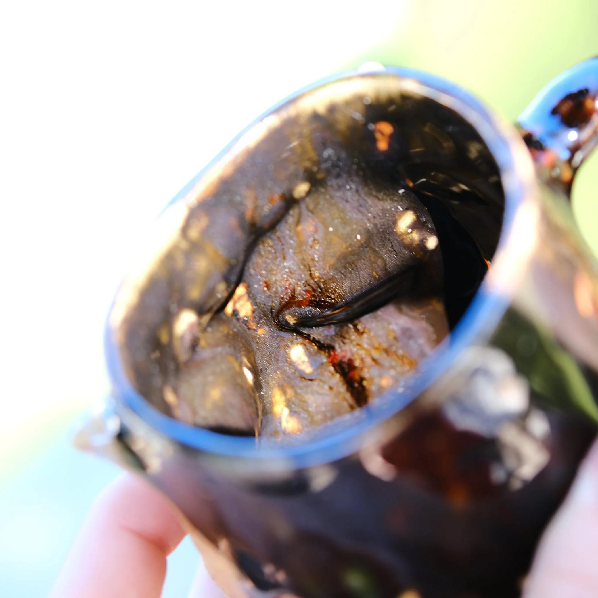 Detail shot of the unique amber treacle glaze dripping over the black stoneware of the Shadow Fairy mug.