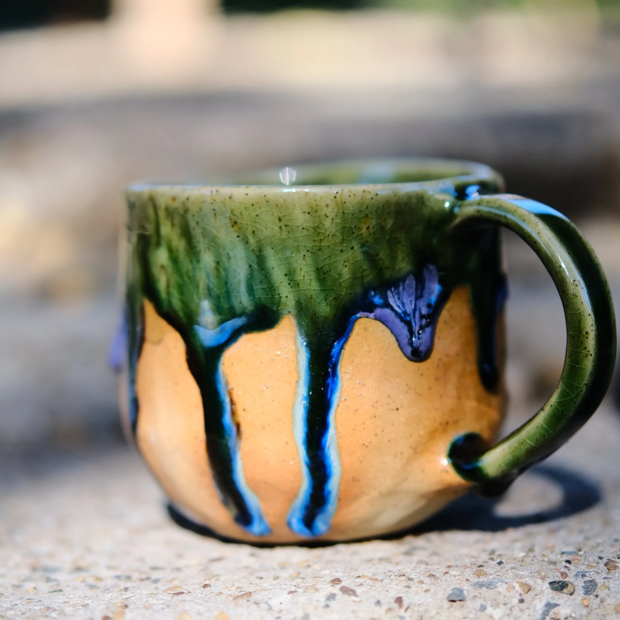 Detailed view of the sturdy ceramic handle and the textured, sandy clay body of the Sunshine Bee pottery mug.
