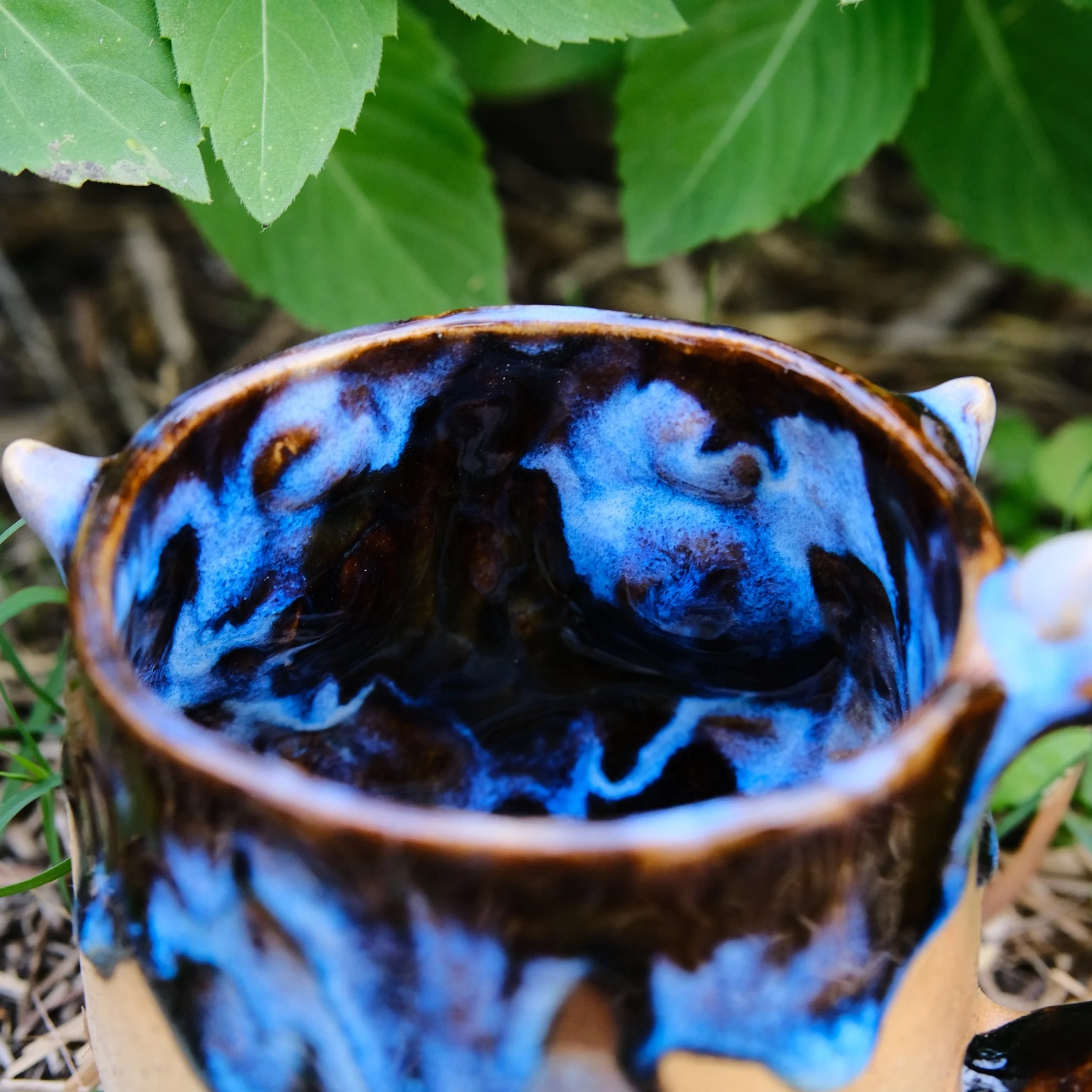 handcrafted artistic mug with multiple eyes and expressive face ceramic art