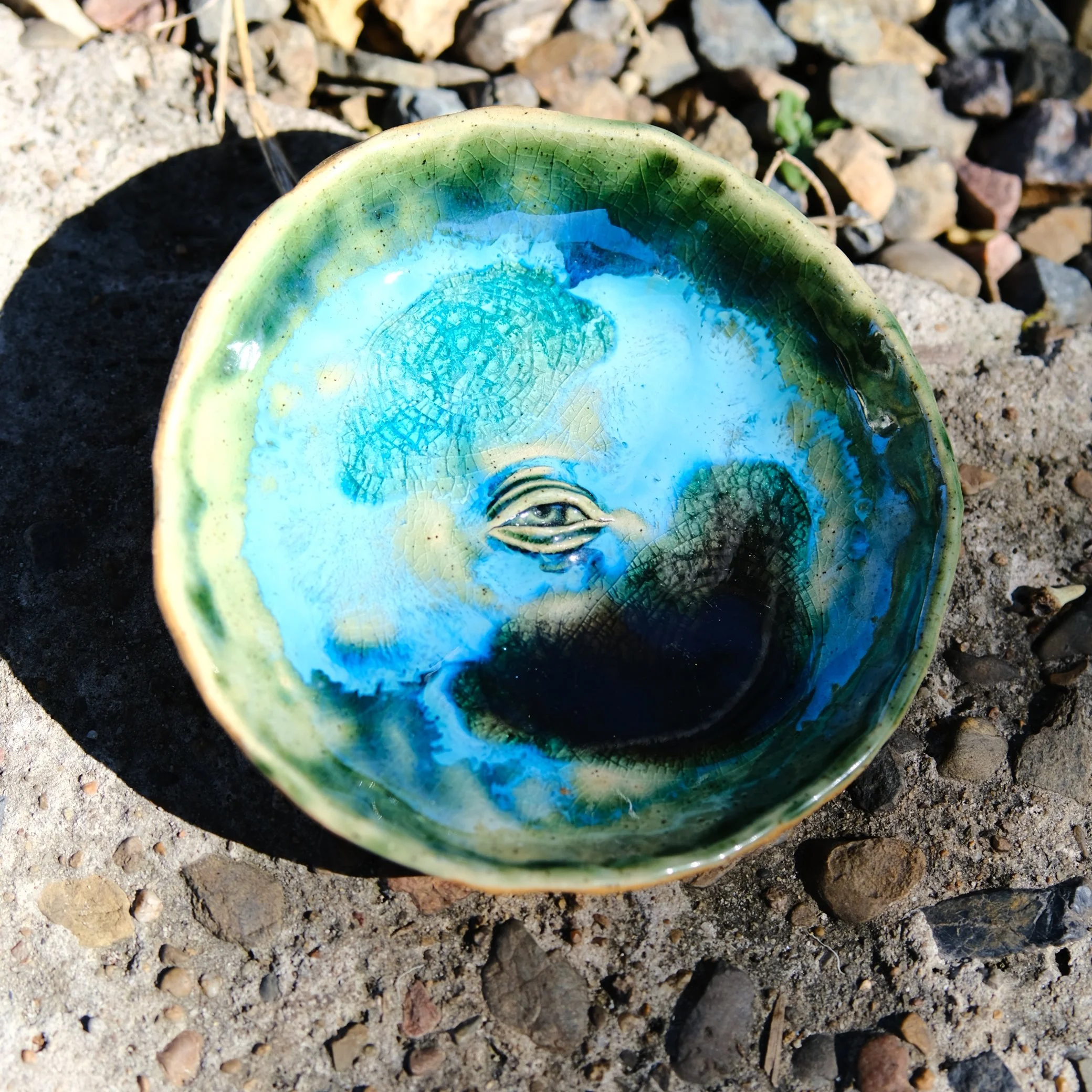The Ocean Eye trinket dish resting on a light-colored surface, showing its vibrant coastal colours and artisanal texture.
