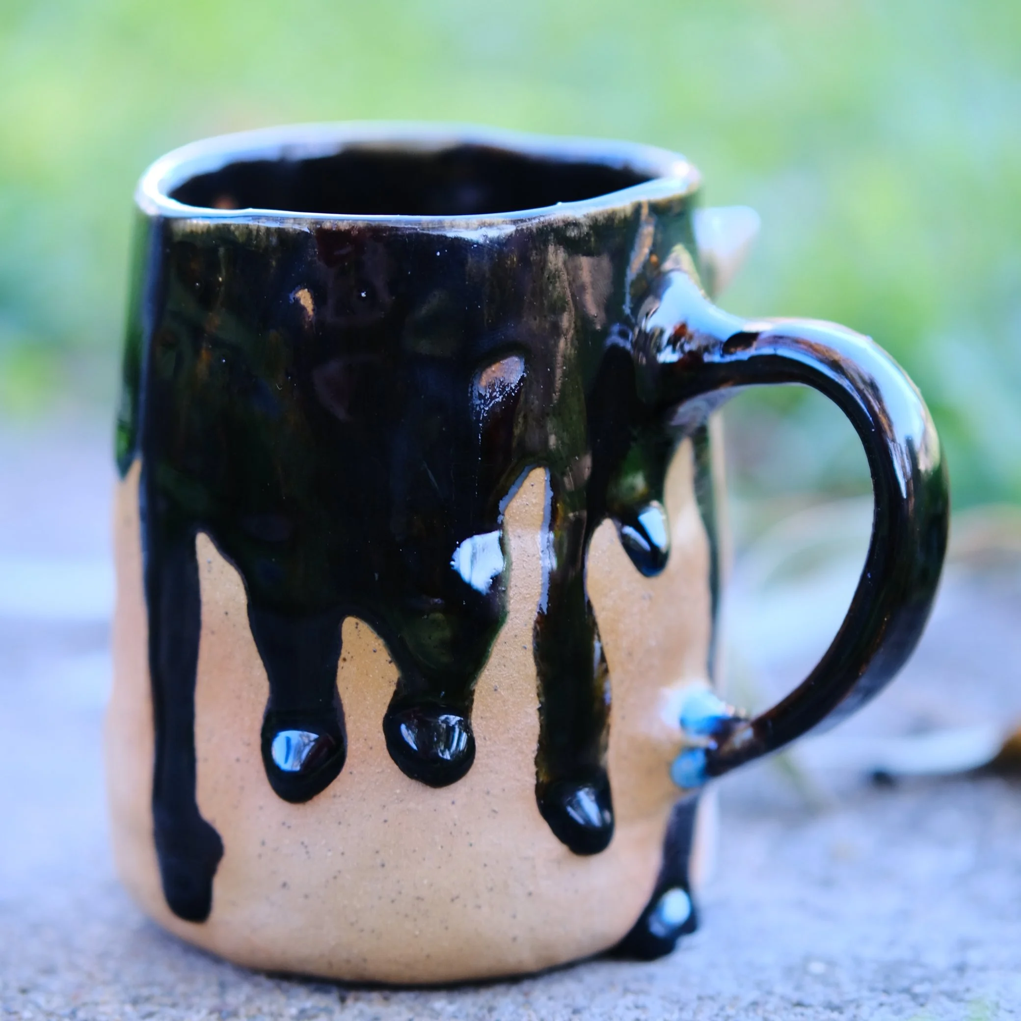 Side profile of the Shadow Fairy handled mug, showing the contrast between the dark glossy glaze and the earthy, magical aesthetic.