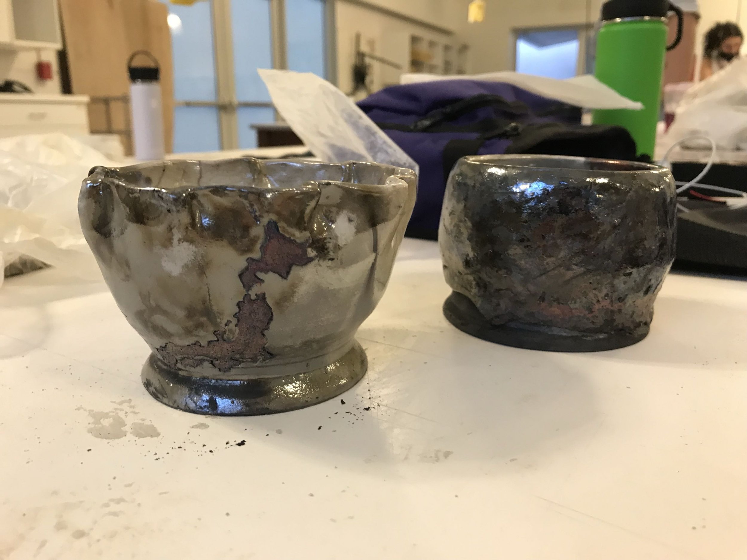 A few more Raku pieces--an experimental cup on the right and an ancient Japanese pottery-inspired bowl on the left complete with the shape of Japan painted on in Raku glaze.