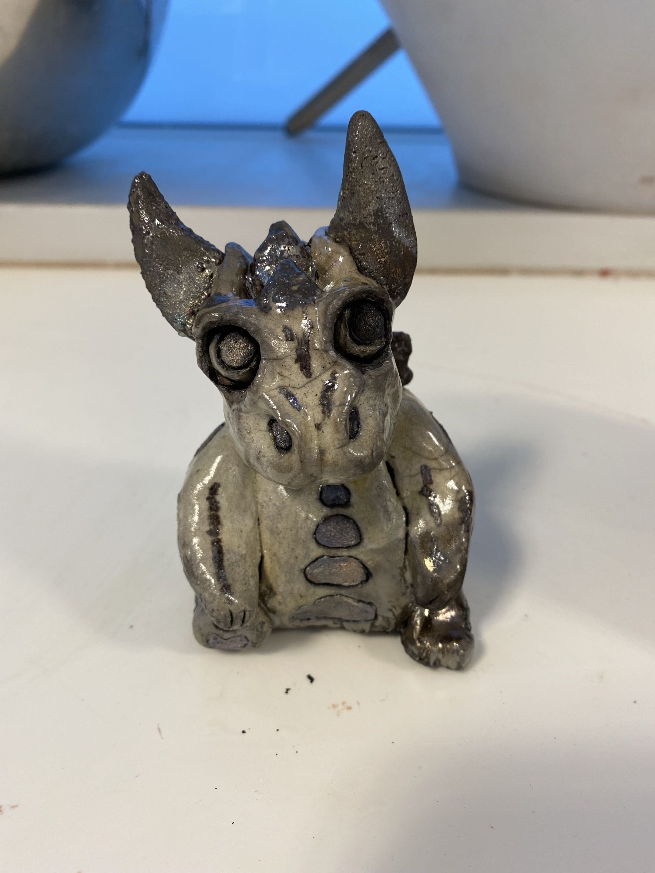 While I was at school, we had access to an American Raku kiln for a time and I loved doing some experiments with the glazes! Here's a hand-built dragon I made as a response to a bowl of mine cracking during the trimming stage. You can see him with hi