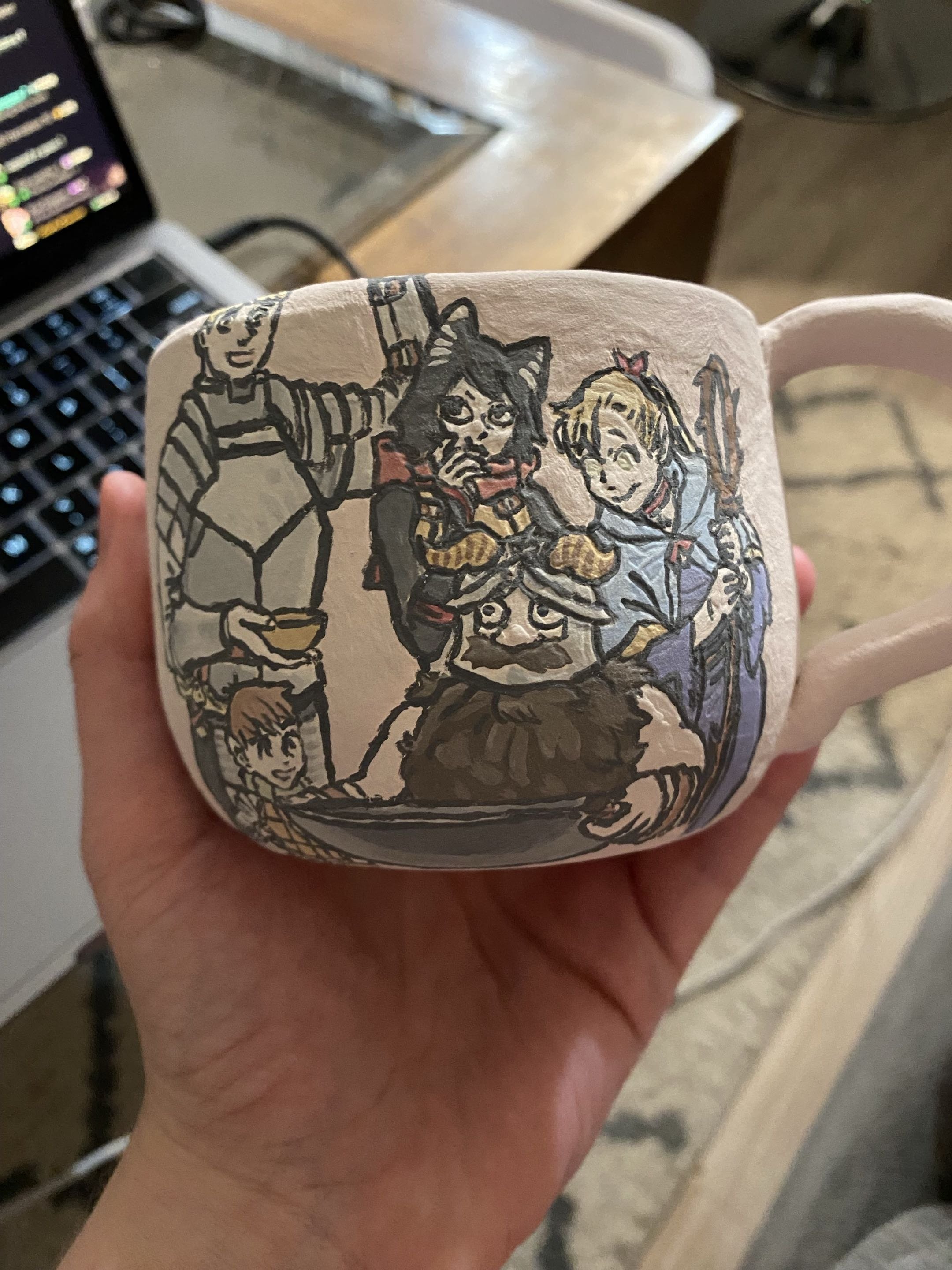 A Dungeon Meshi cup I made for a friend! Unfortunately as you can see in the next slide the clear glaze I picked didn't end up reacting well to the underglaze and it ran a bit, which is why I decided to include the pre-fire image as well. Very proud 