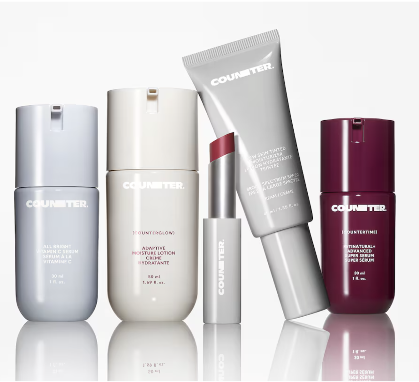 Collection of five skincare products, including bottles and tubes, with the brand name 'Counter' on each, arranged on a reflective surface.