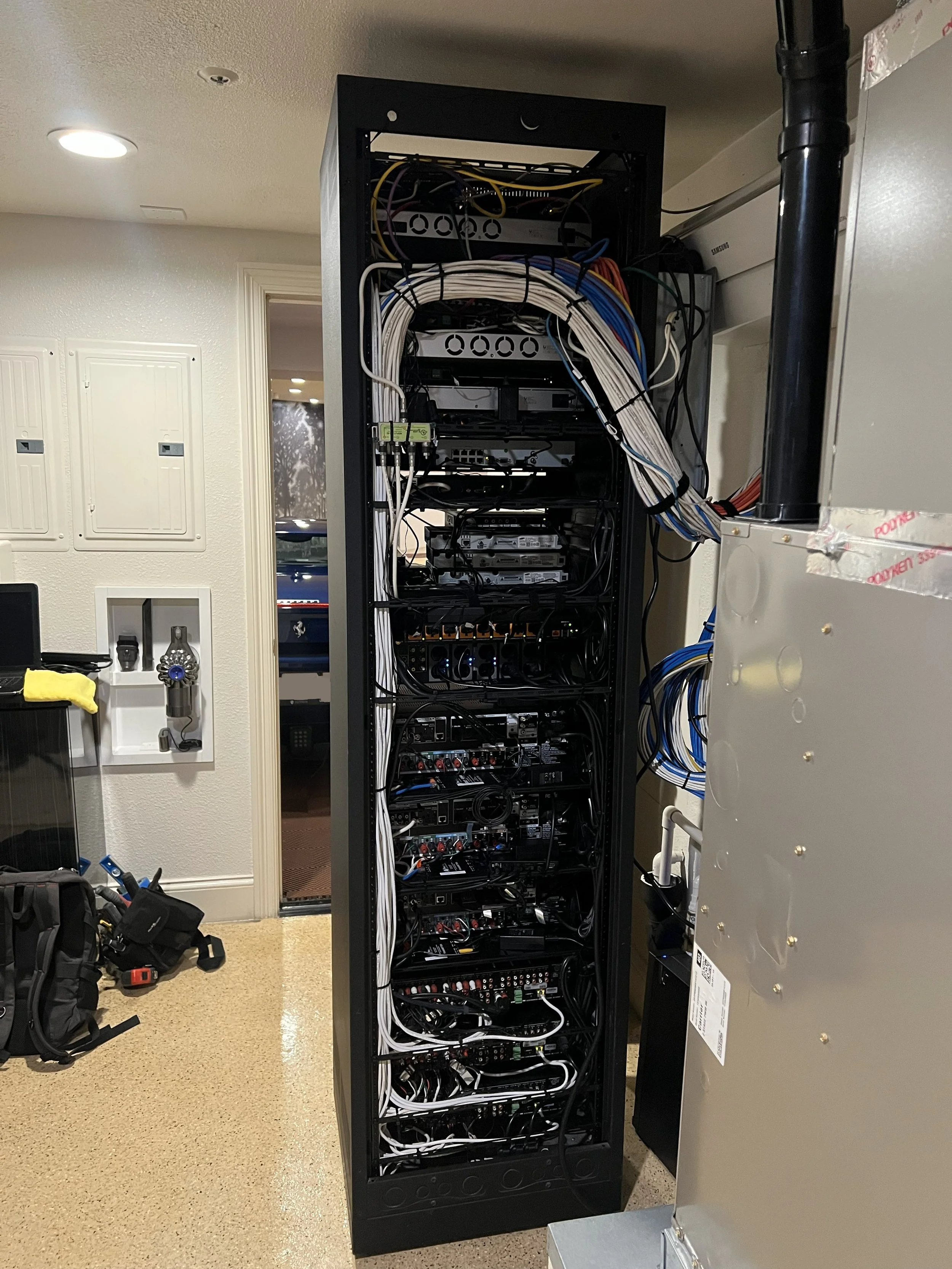 Setting up a black server rack filled with networking and electronic equipment - located in New Port Beach, CA