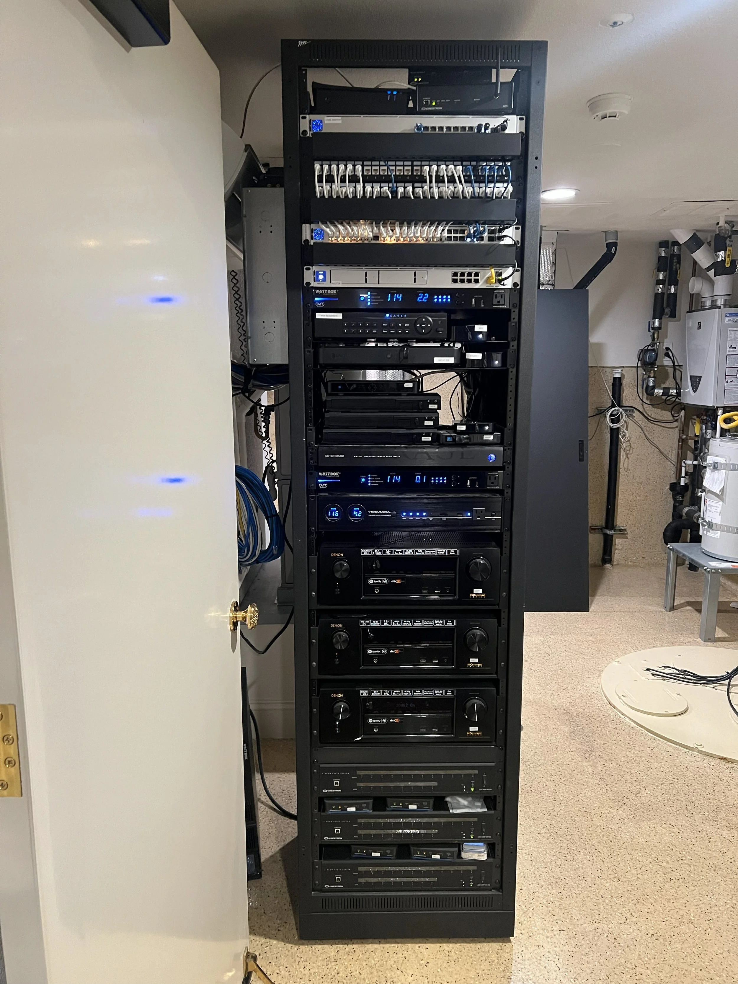Setting up a black server rack filled with networking and electronic equipment - located in New Port Beach, CA