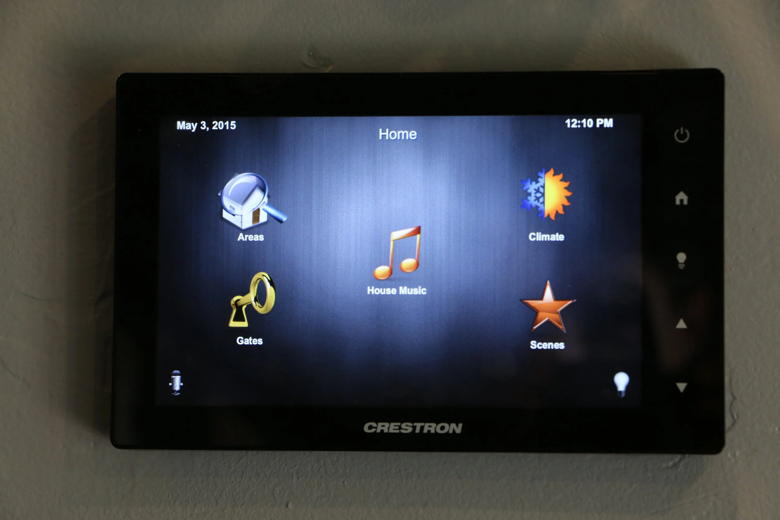 A Crestron home automation touchscreen display showing menus for Areas, Gates, House Music, Climate, and Scenes. Home Automation from access control to audio, video, lighting control and CCTV using Creston as a control system.