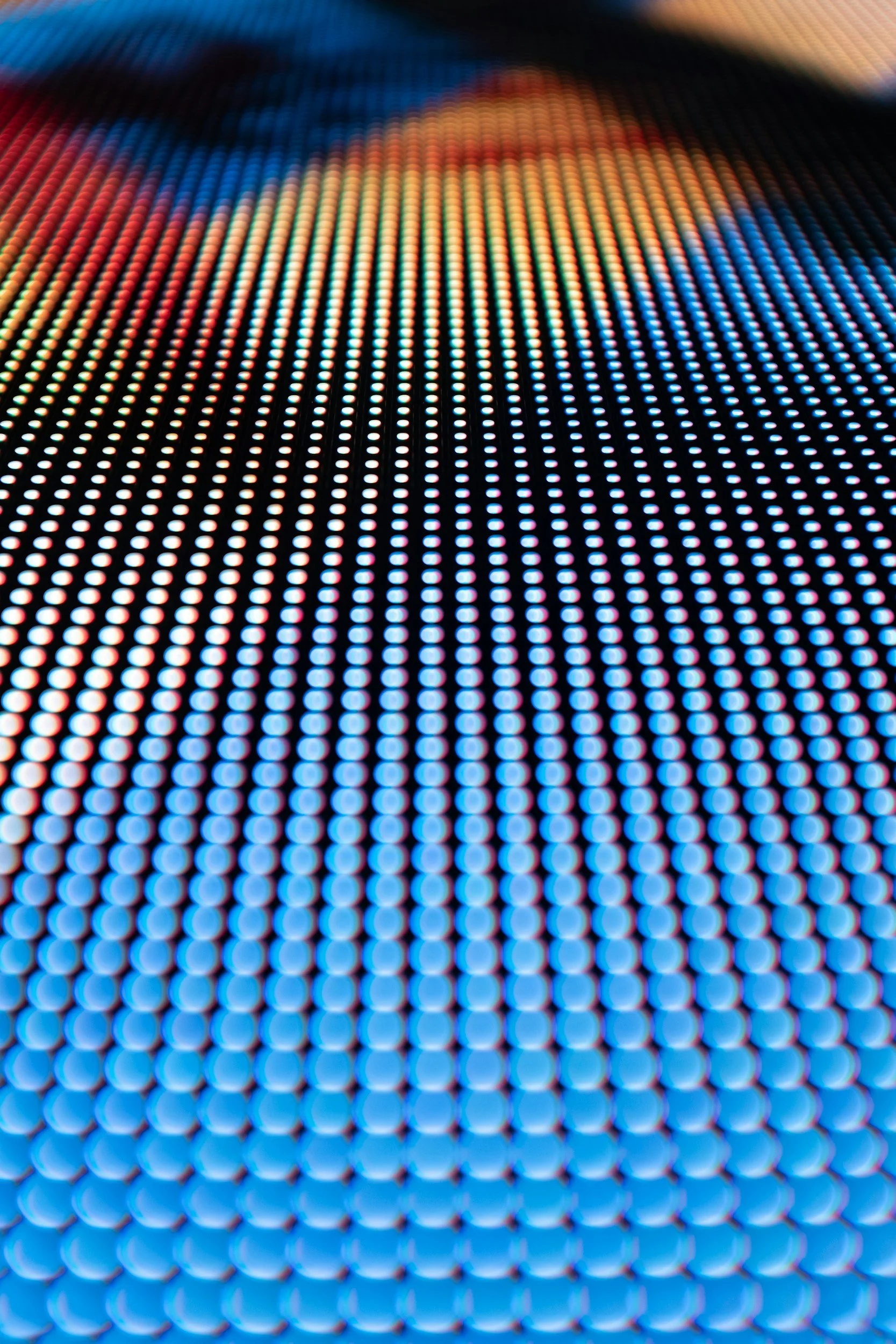Close-up of a colorful LED digital display with a pattern of small round lights in various colors, creating a vibrant, futuristic appearance.