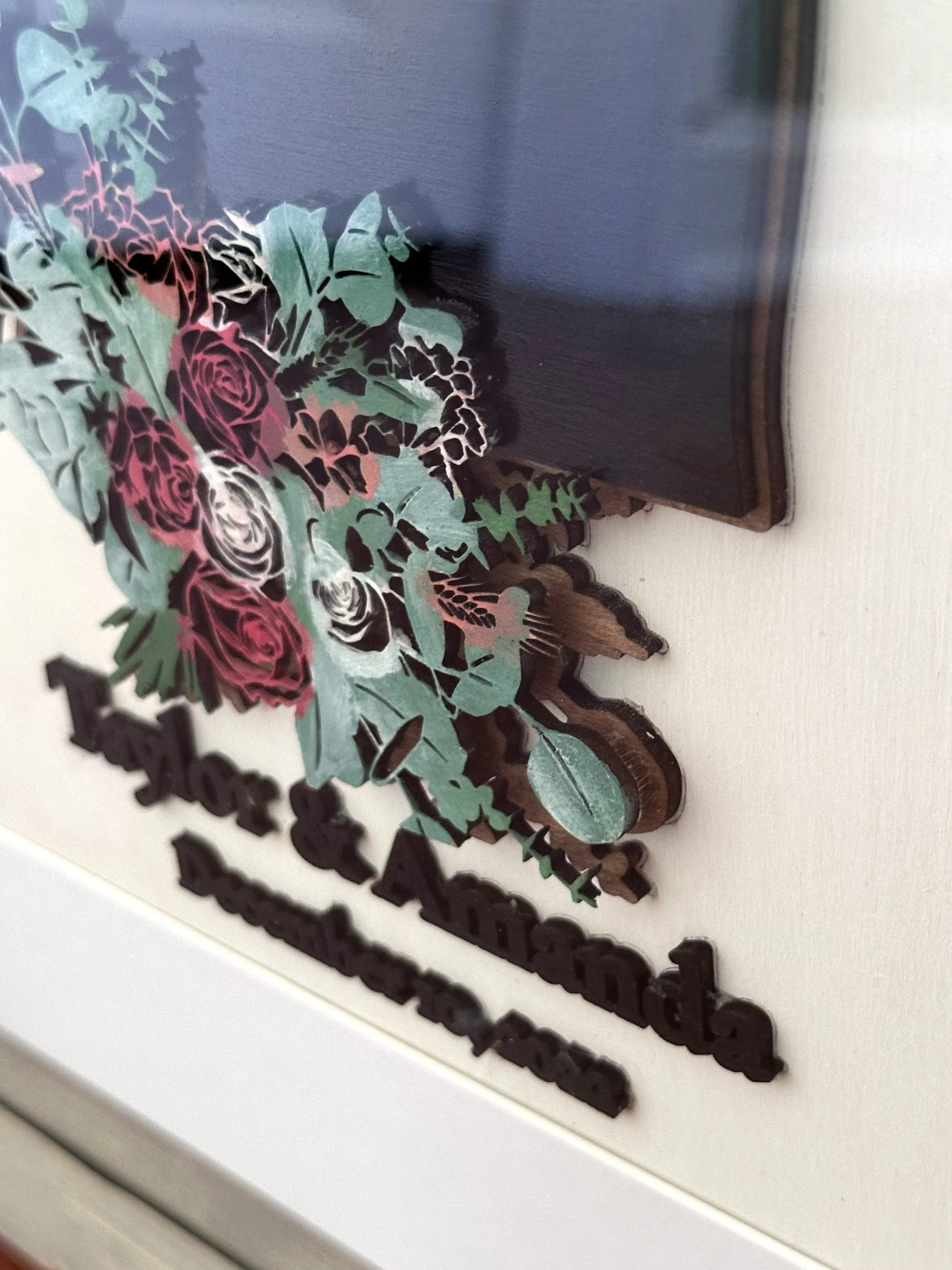 A decorative plaque with a floral design, featuring roses and greenery, and text that reads 'Happy Mother's Day.'