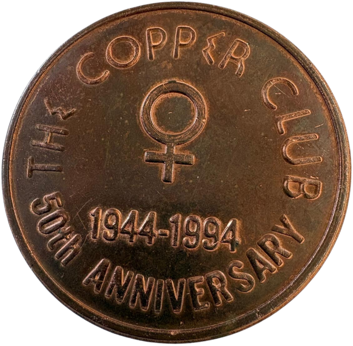 Close-up of a copper coin featuring the symbols and text commemorating the 50th anniversary of the Women's Army Corps, with dates 1944-1994.