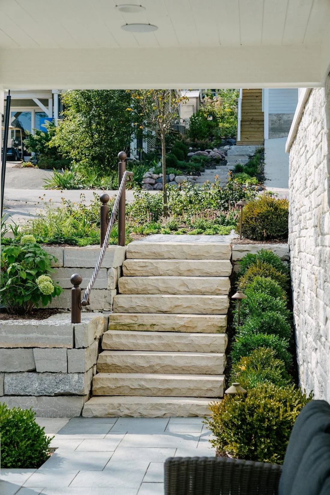 Limestone slab steps and retaining walls viewed from a covered patio by ILT Vignocchi