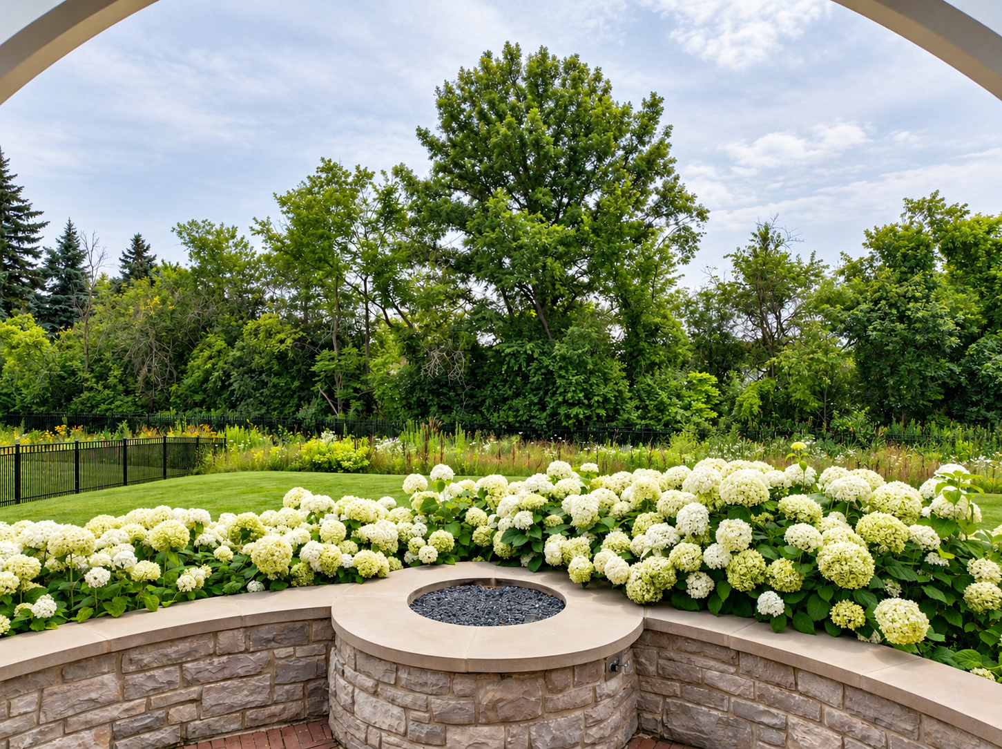 Stone retaining wall with attached fire pit and hydrangeas