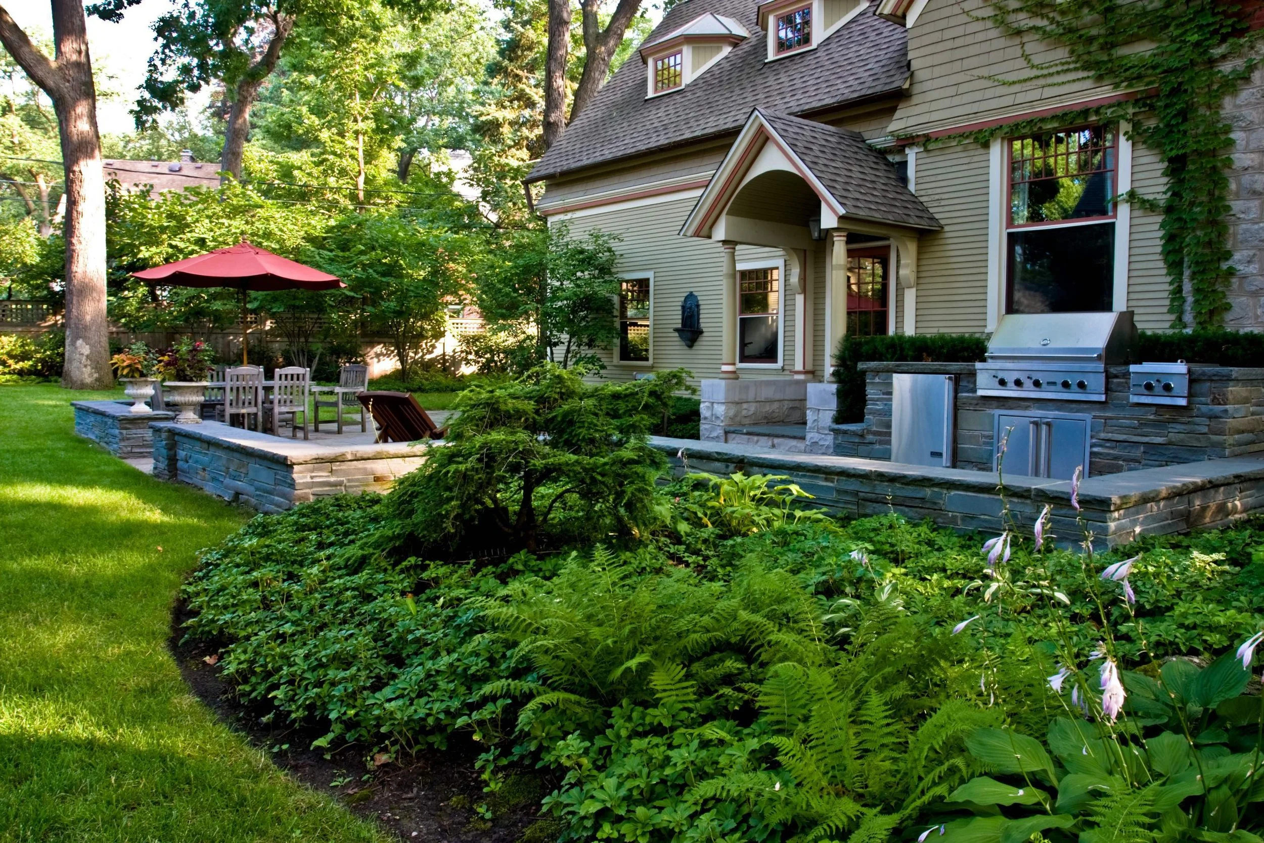 Stone retaining wall and grill for outdoor kitchen by ILT Vignocchi