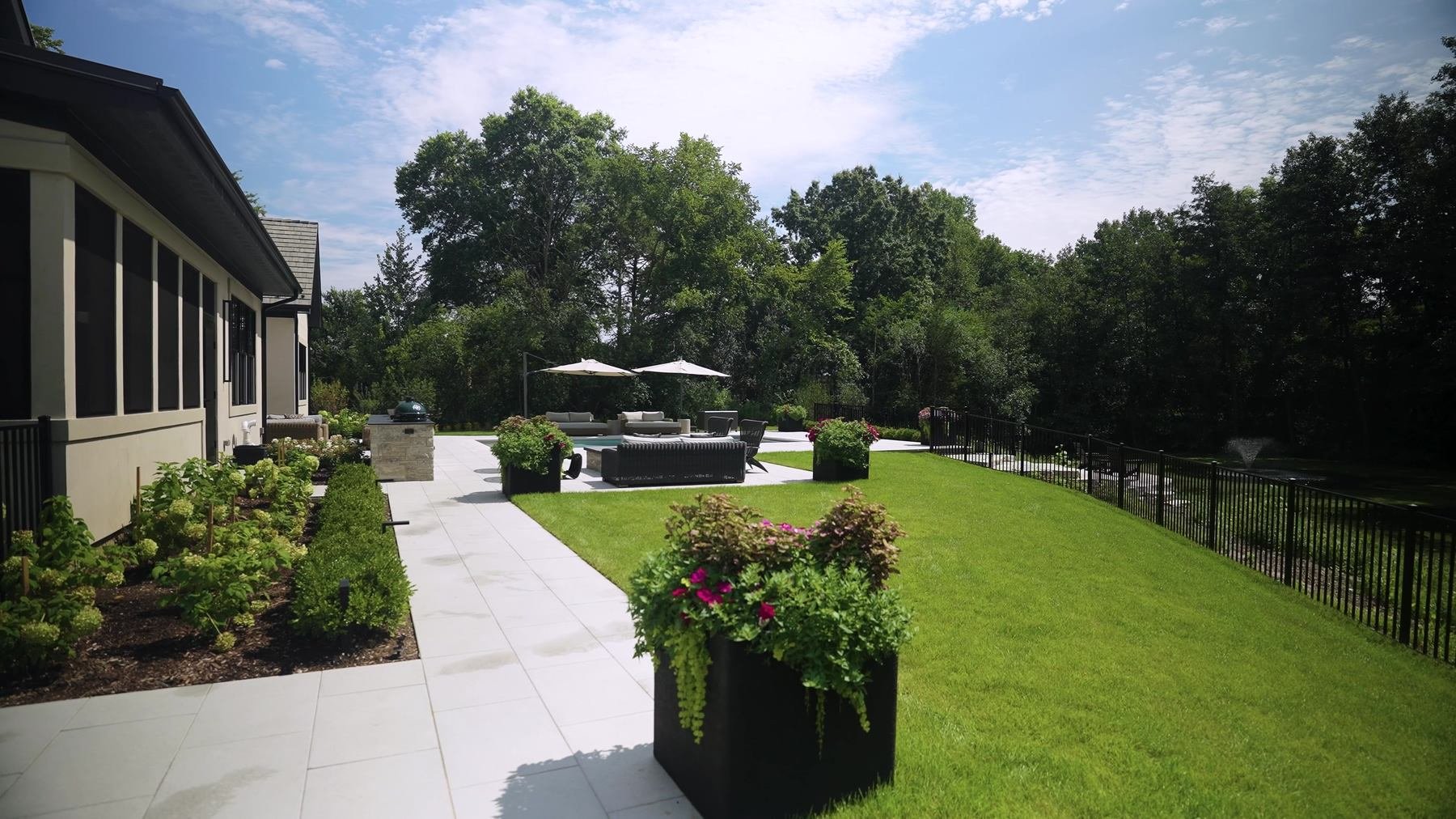 Lawn and patio with container plantings by ILT Vignocchi