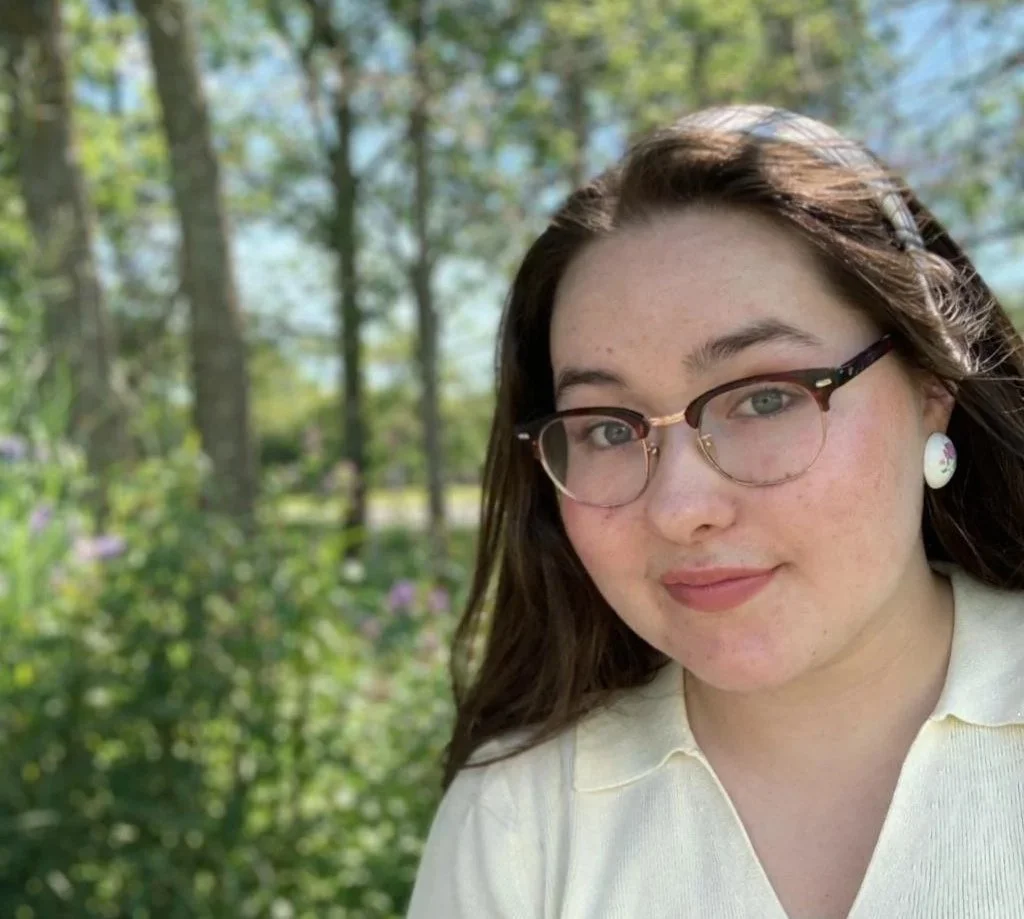 Profile photo of Maya outside surrounded by greenery