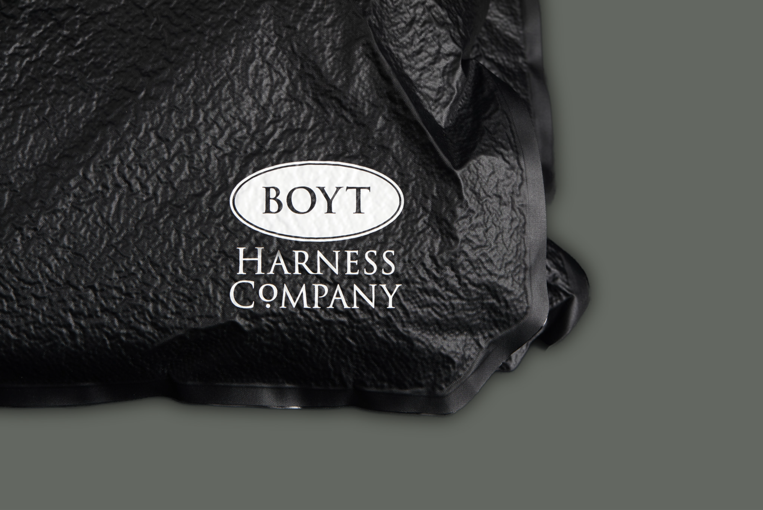 Black textured bag with a white oval logo reading 'BOYT' and the words 'HARNESS COMPANY' printed below.