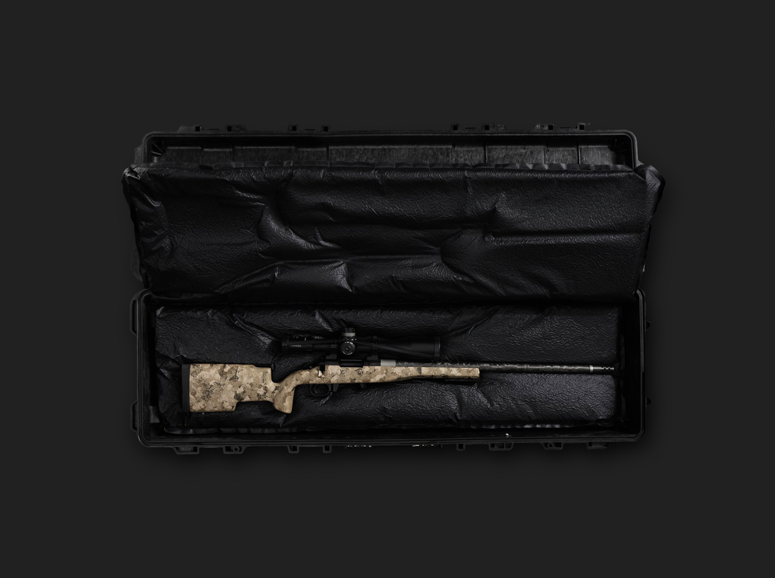 A black gun case with foam padding inside, containing a disassembled firearm with a scope mounted on the barrel, and a camouflage fabric piece underneath.