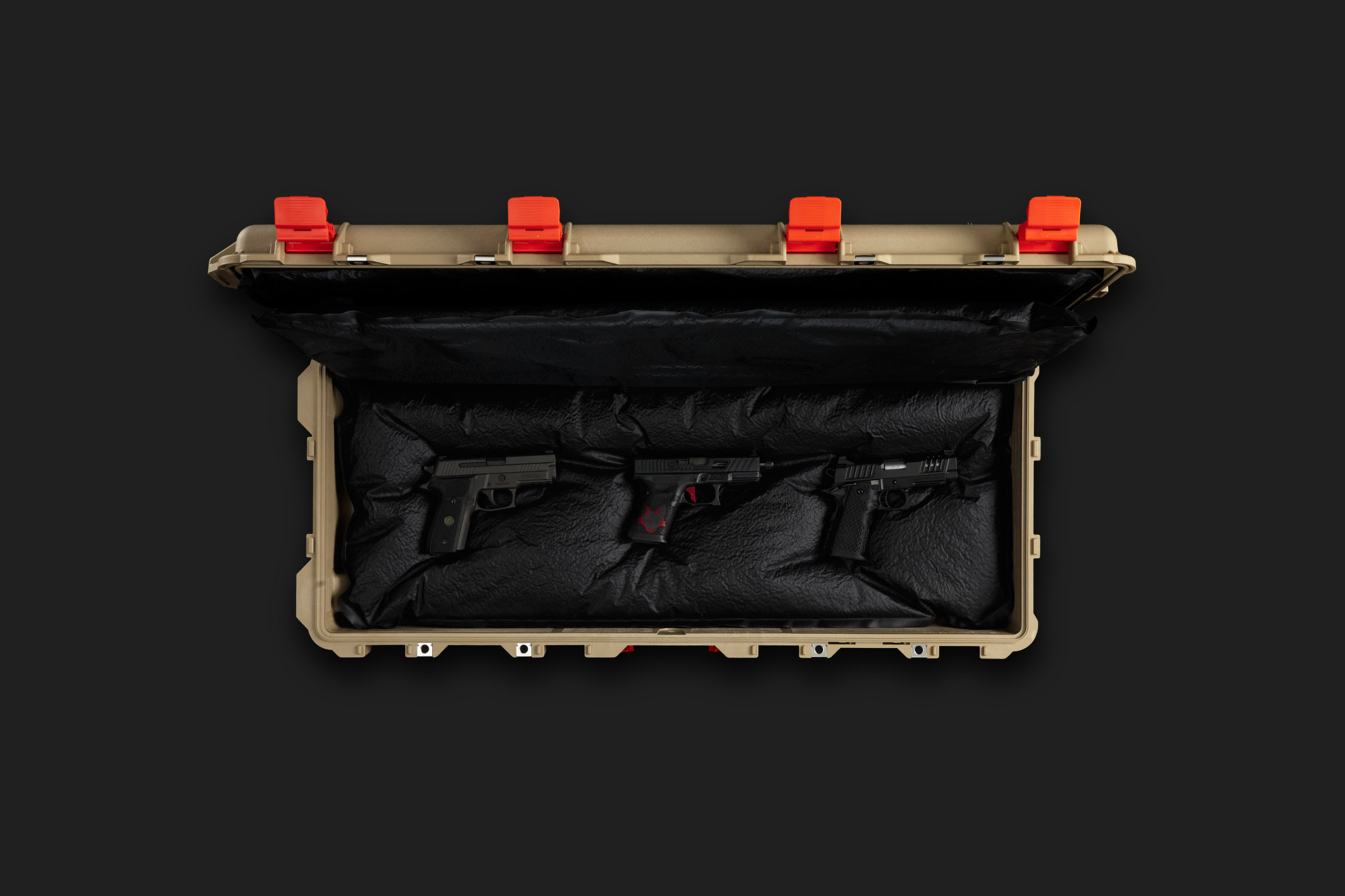 A tan hard plastic carrying case with black foam padding, containing a black handgun with a red logo, and a black ammunition magazine, with a black background.