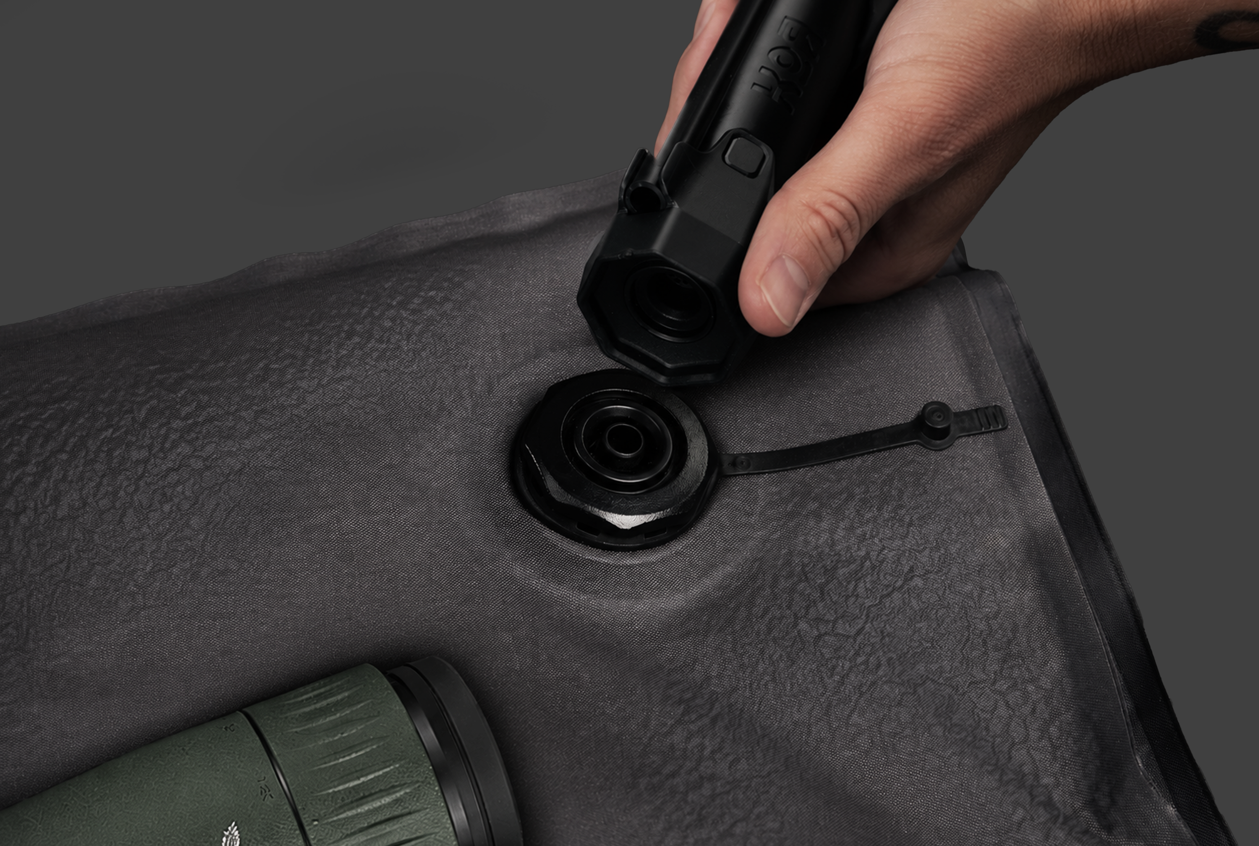 A close-up of a person's hand holding using the KOR vacuum pump to rigidize the KOR protection System