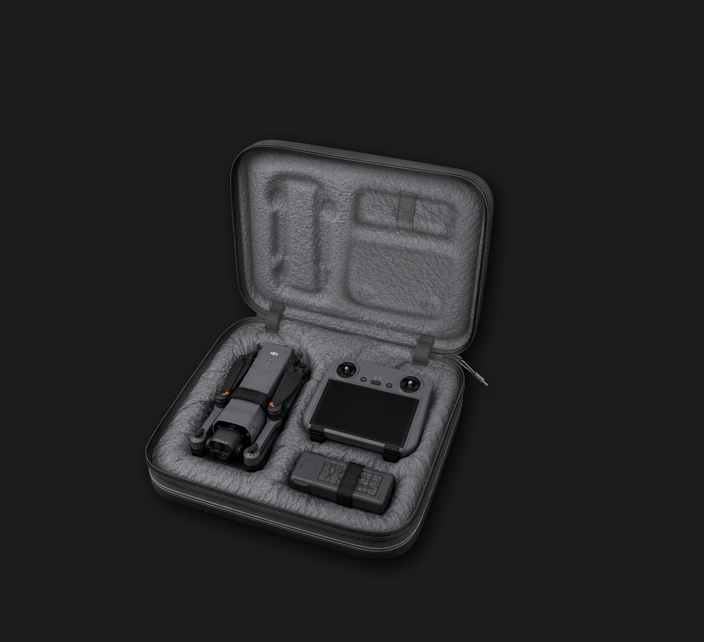 A black hard case with a protective grey foam interior, containing a drone, its remote controller, a battery, and a charger.
