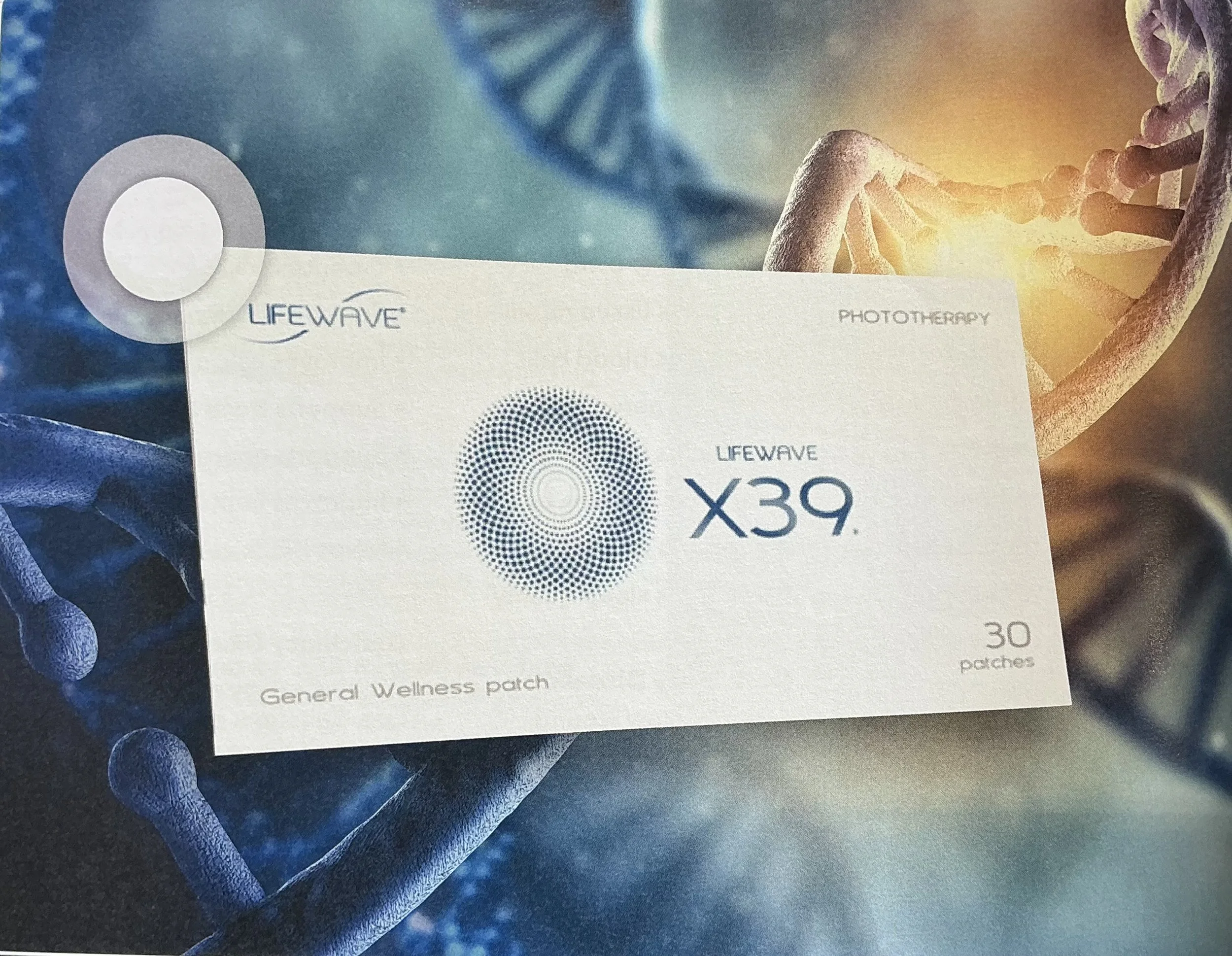 Box of LifeWave X39 phototherapy patches with a DNA strand background