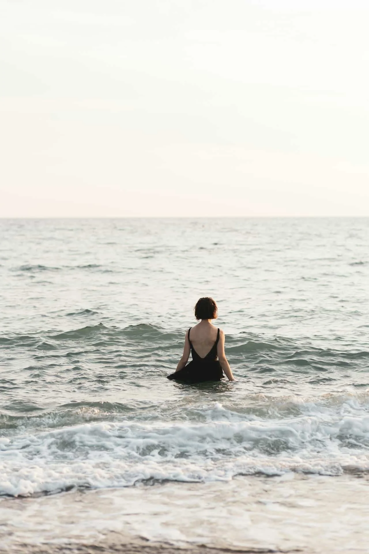 woman in dress standing in ocean