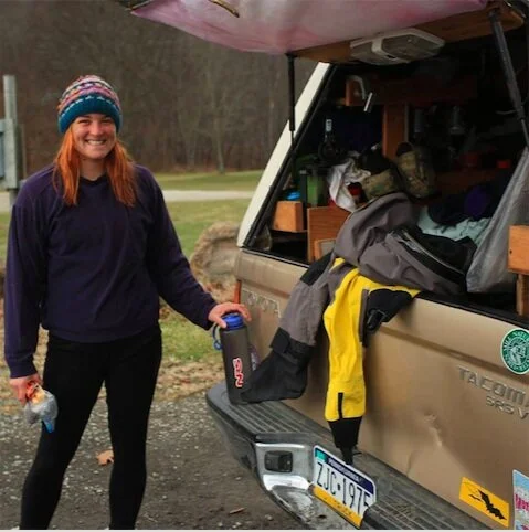 Photo of woman behind truck preparing to white water raft