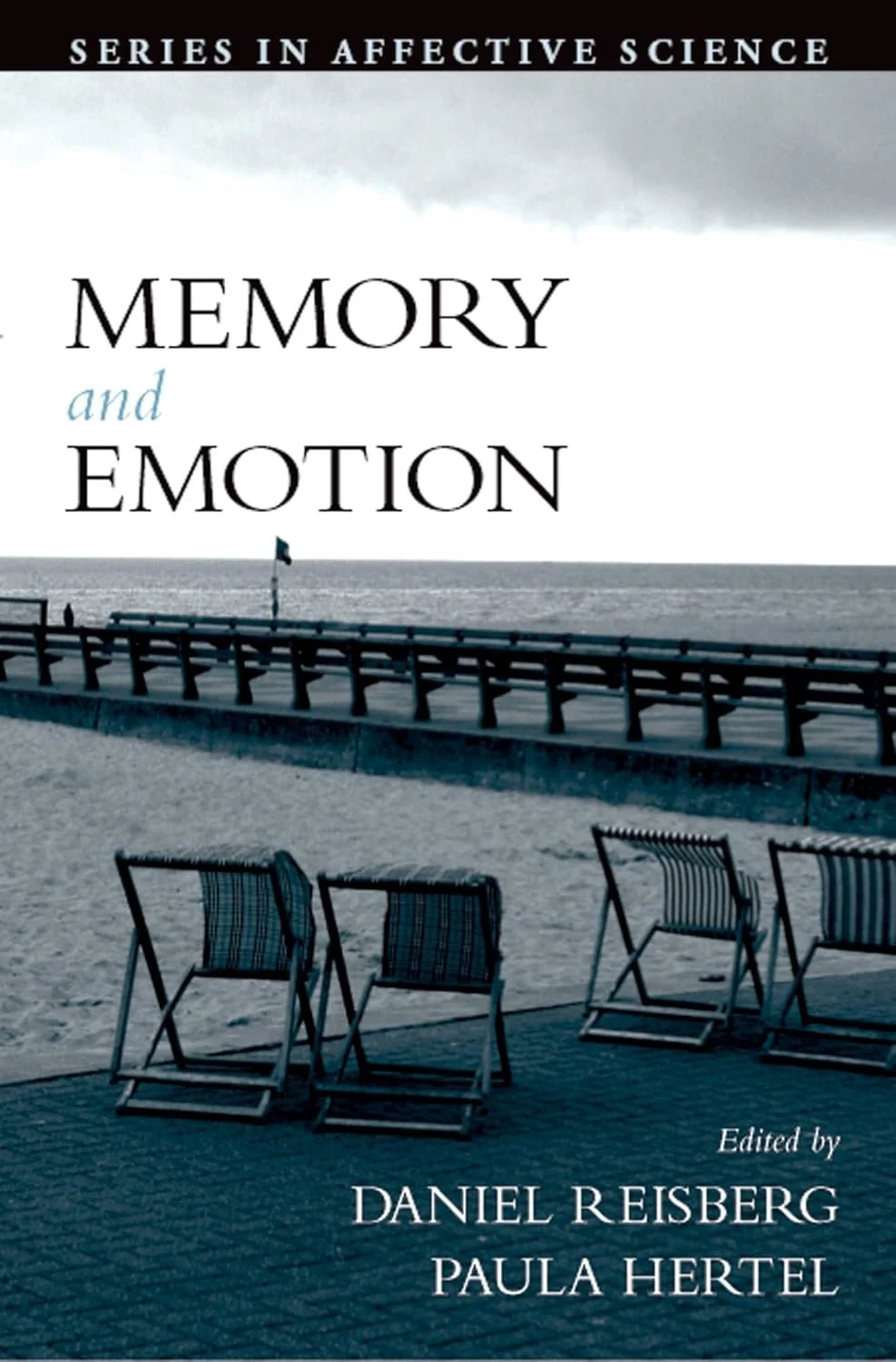 Book cover of 'Memory and Emotion' with a beach scene featuring a wooden pathway, beach chairs, sandy shore, and ocean view in black and white tones.