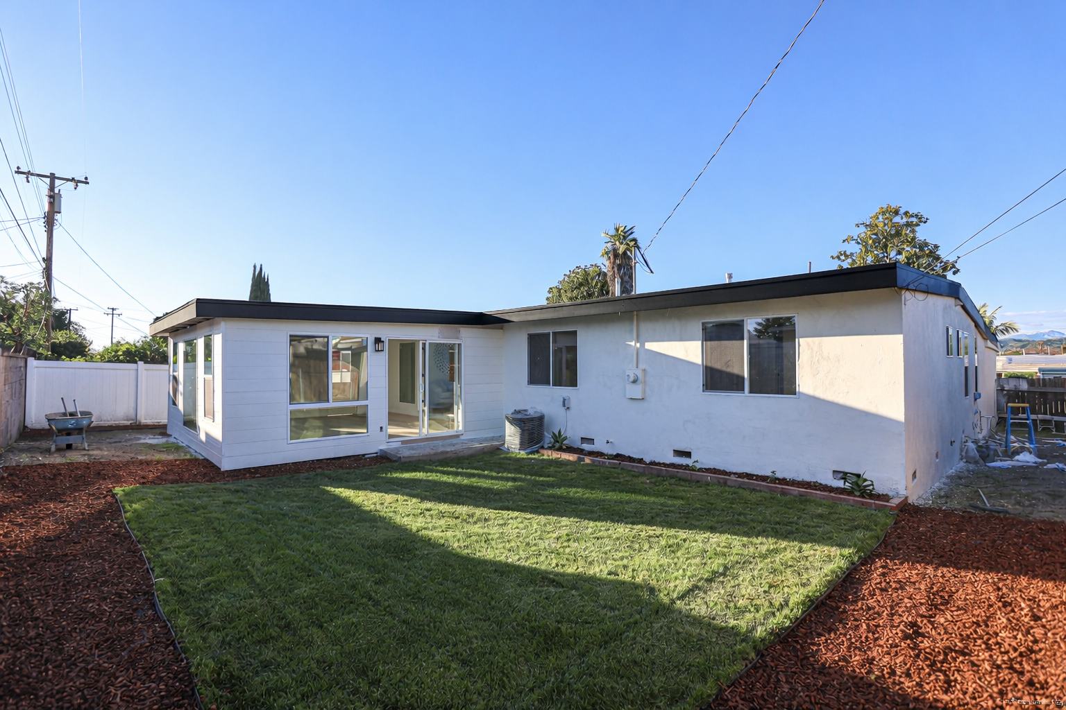 Modern backyard with green lawn and fence.png
